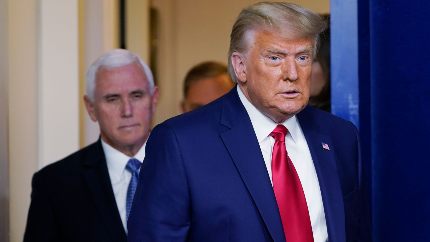 Luego, el presidente Donald Trump y su entonces vicepresidente, Mike Pence, ingresan a una sala de conferencias de prensa.