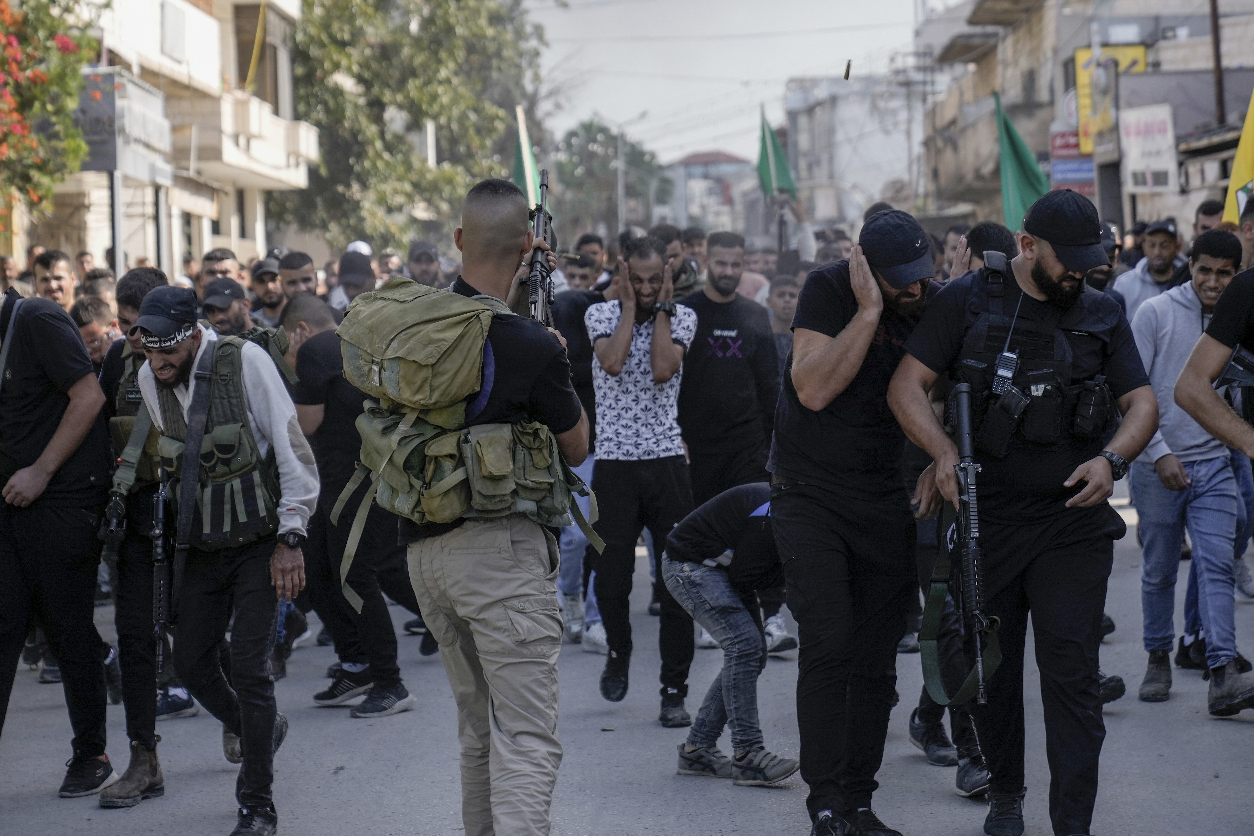 Palestinian gunman shoots in the air during the funeral of three Palestinians killed in an overnight Israeli army raid at the Jenin refugee camp, West Bank Friday, Nov. 17, 2023. 