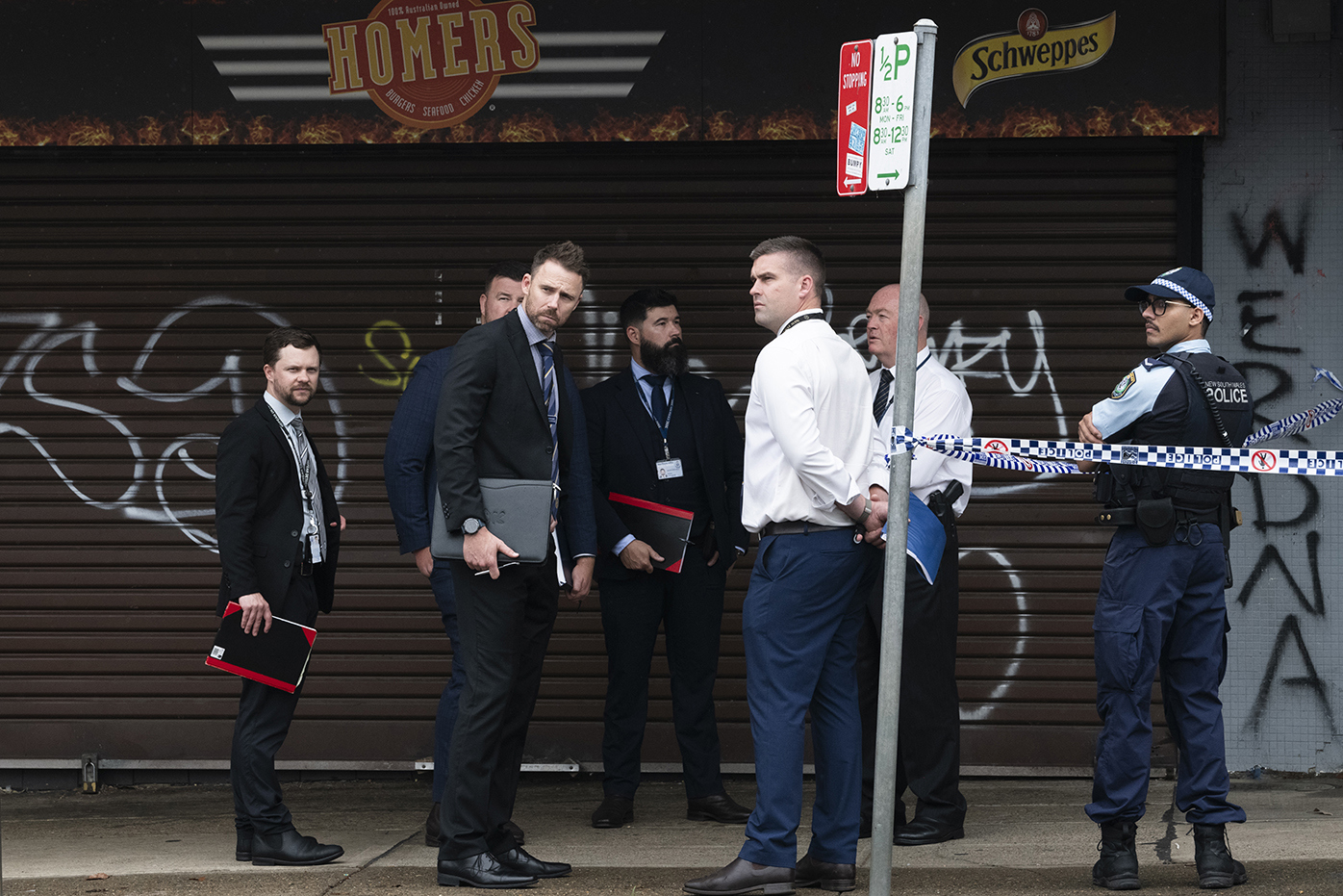 Two bodies have been found on Oxford St, Cambridge. Possible family members of the victims are escorted by the police.November 30, 2024. Photo: Rhett Wyman / SMH