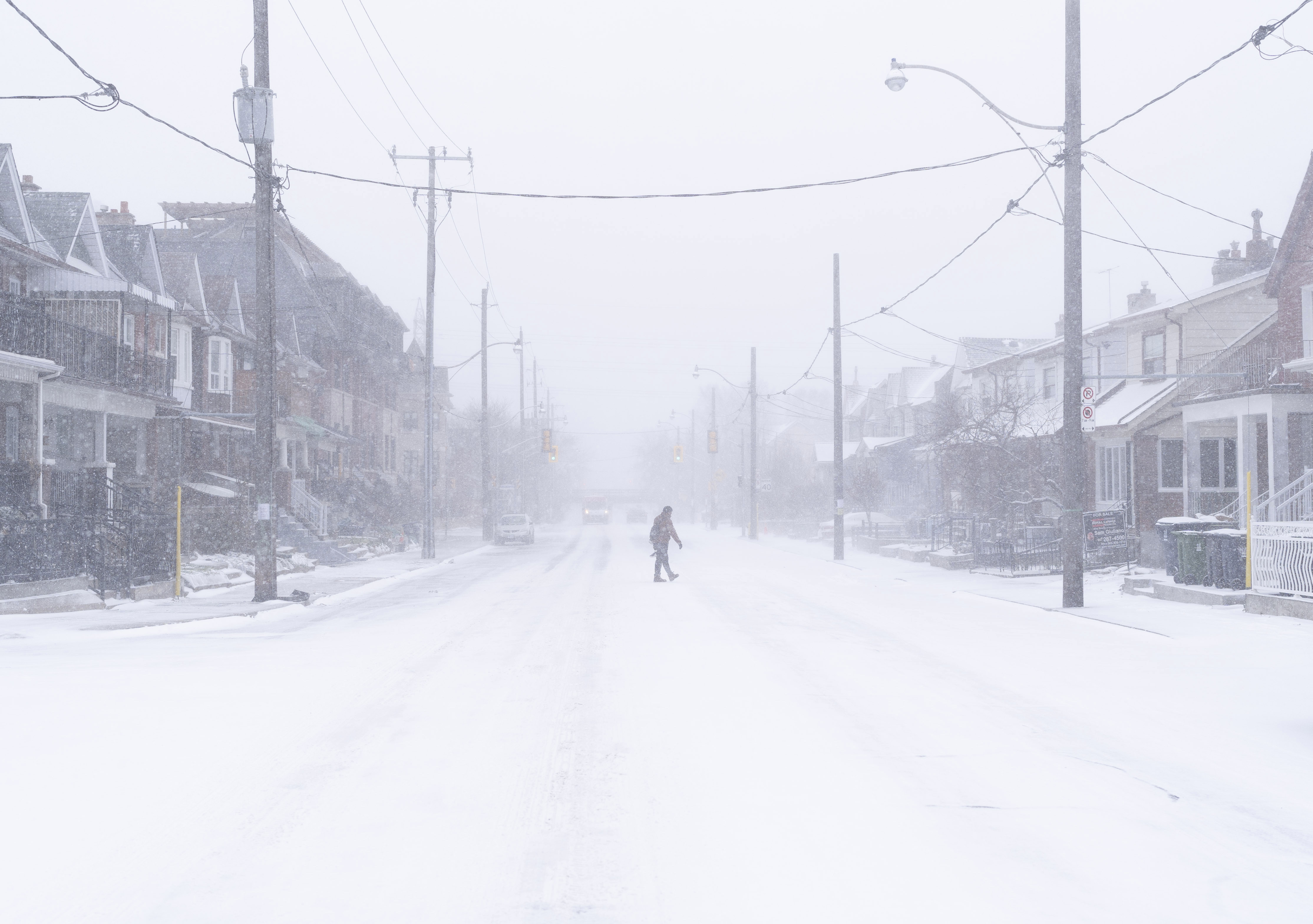 Un hombre cruza una carretera durante una tormenta de nieve en Toronto el viernes 23 de diciembre de 2022. Hay una advertencia de tormenta invernal para la mayor parte del sur de Ontario.  (Arlyn McAdorey/The Canadian Press vía AP)