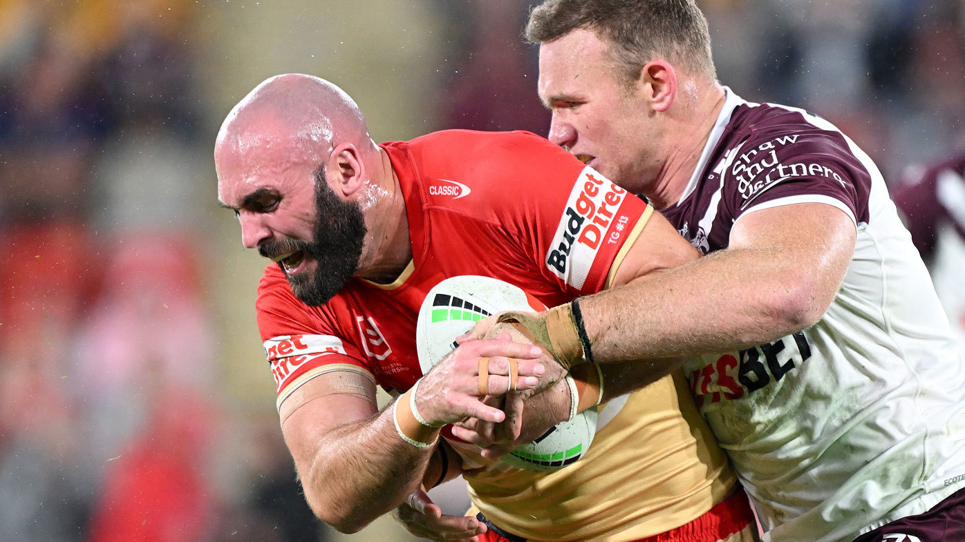 Dolphins forward Mark Nicholls is tackled by Manly's Matt Lodge.