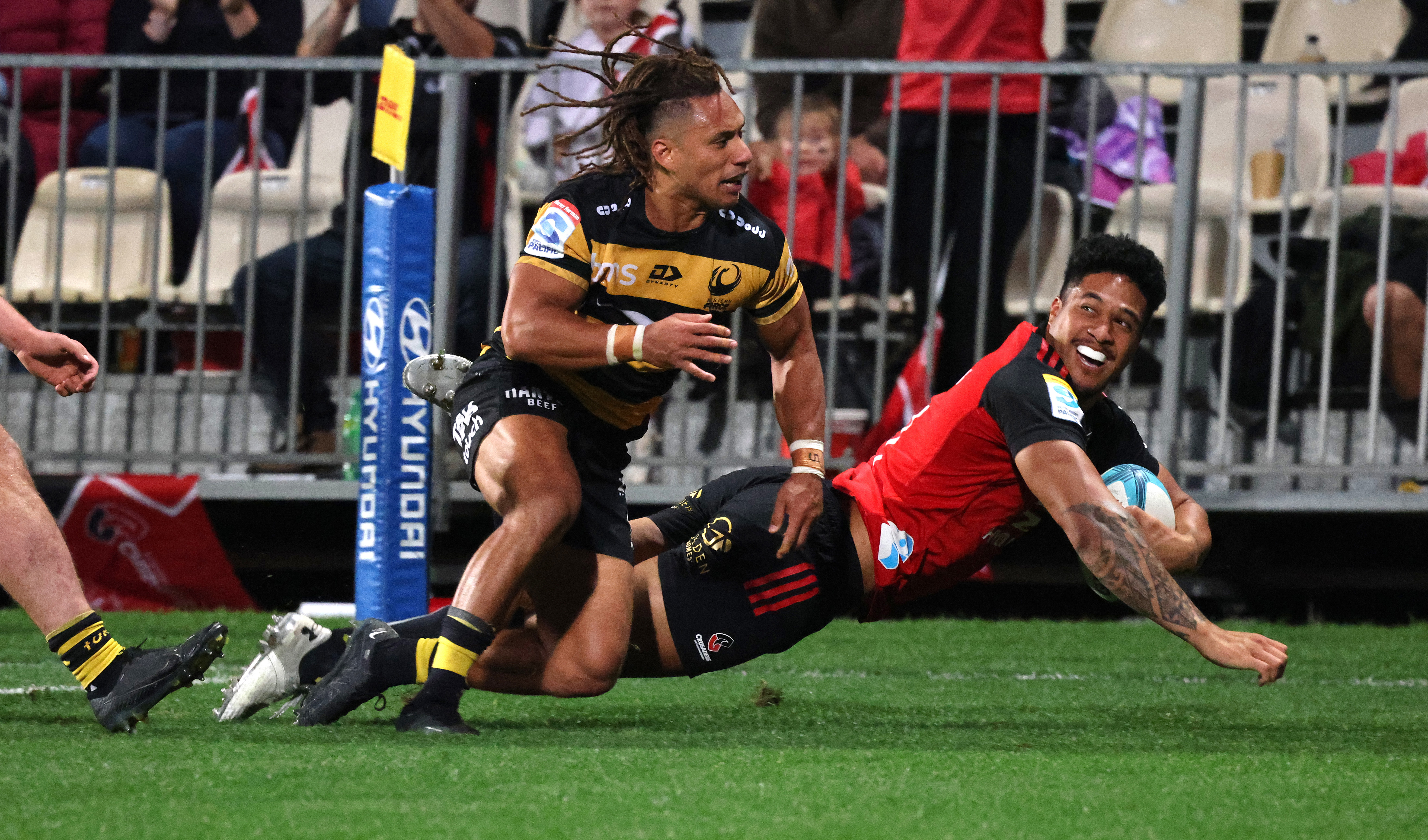 Leicester Fainga'anuku of the Crusaders dives to score past Issak Fines-Leleiwasa of the Force.