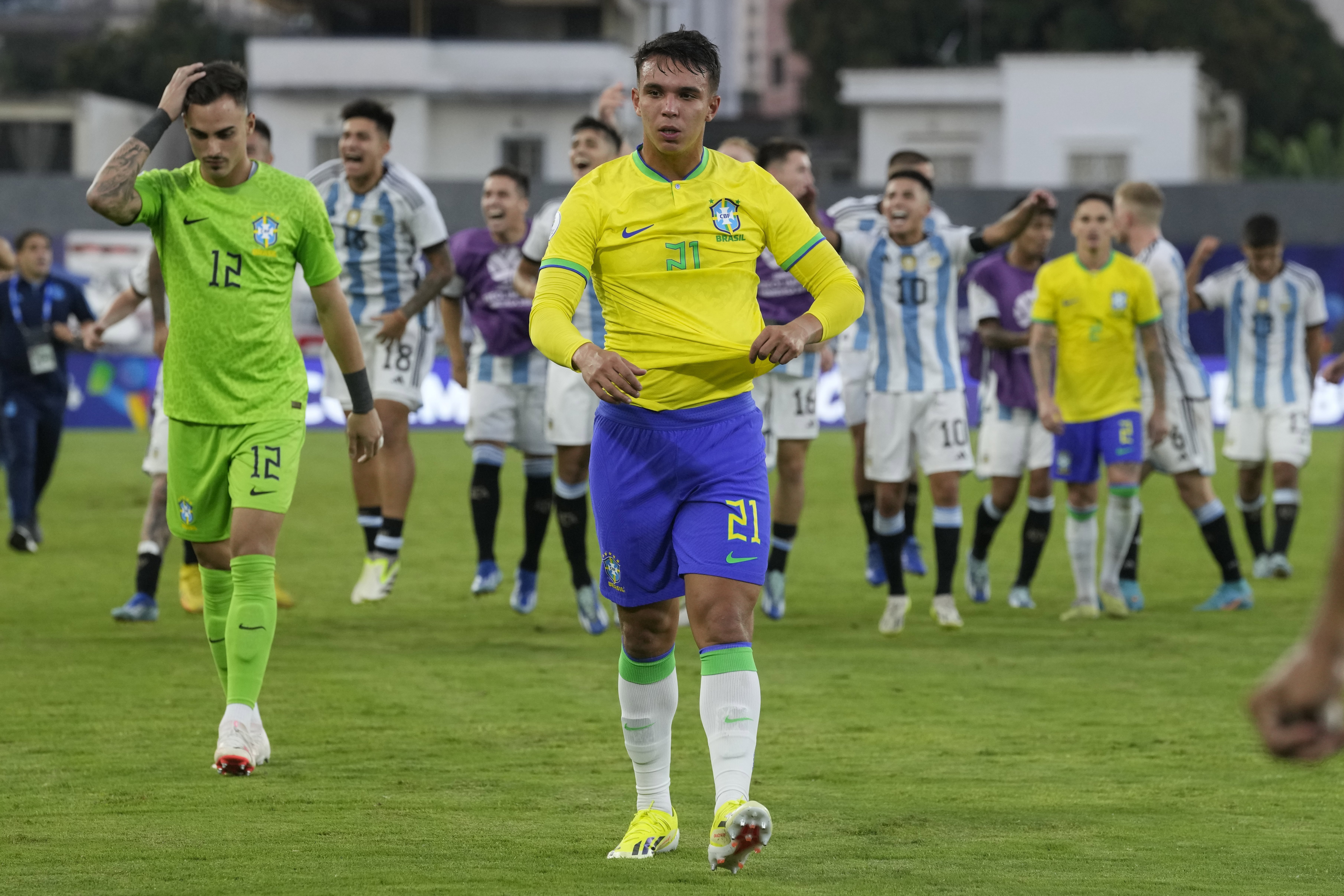Brazil's Geovane and goalkeeper Matheus Donelli walk off the field after their 0-1 loss.