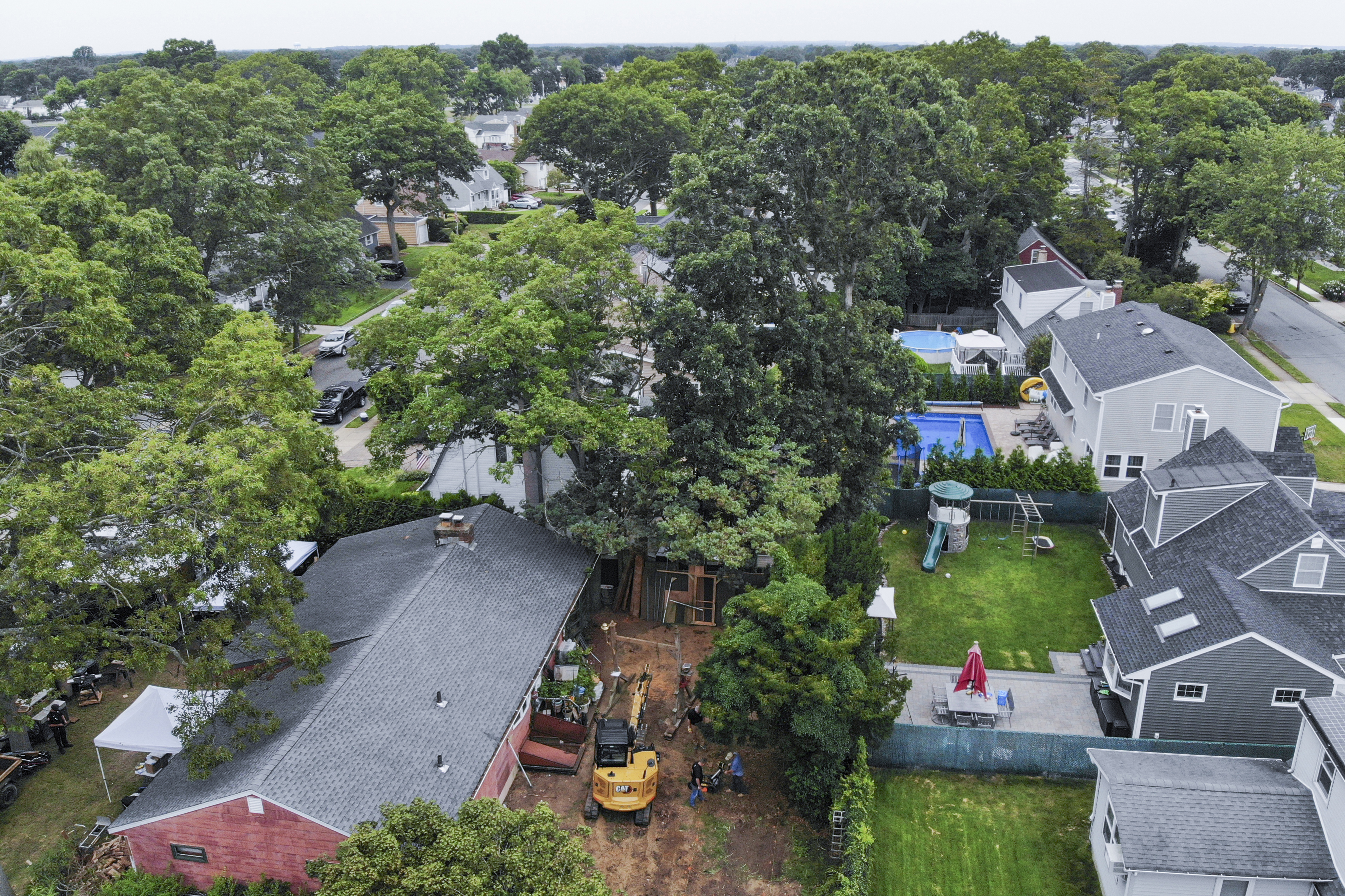 Authorities continue to work at the home of suspect Rex Heuermann, bottom left, in Massapequa Park, N.Y., Monday, July 24, 2023. Heuermann has been charged with killing at least three women in the long-unsolved slayings known as the Gilgo Beach killings. 