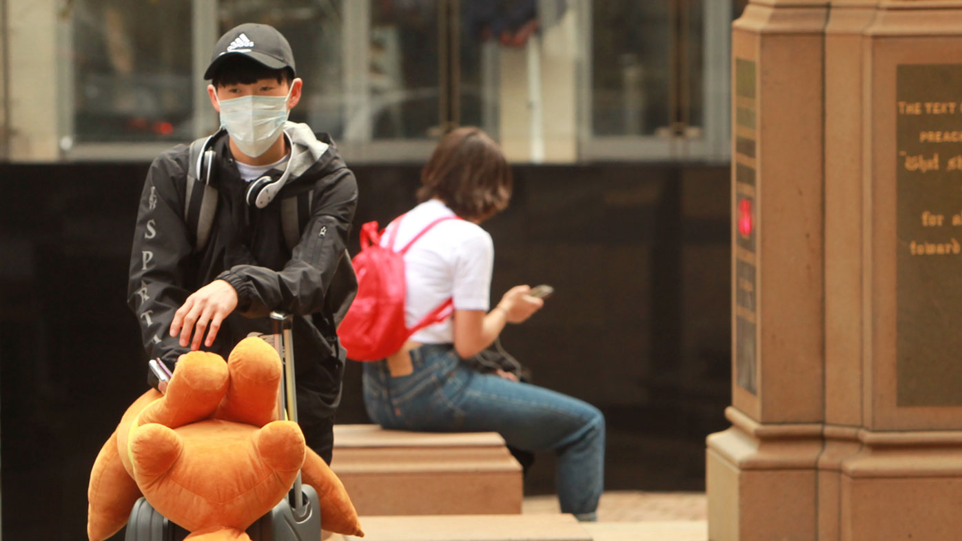 A young man wears a face mask in Sydney to prevent getting coronavirus.