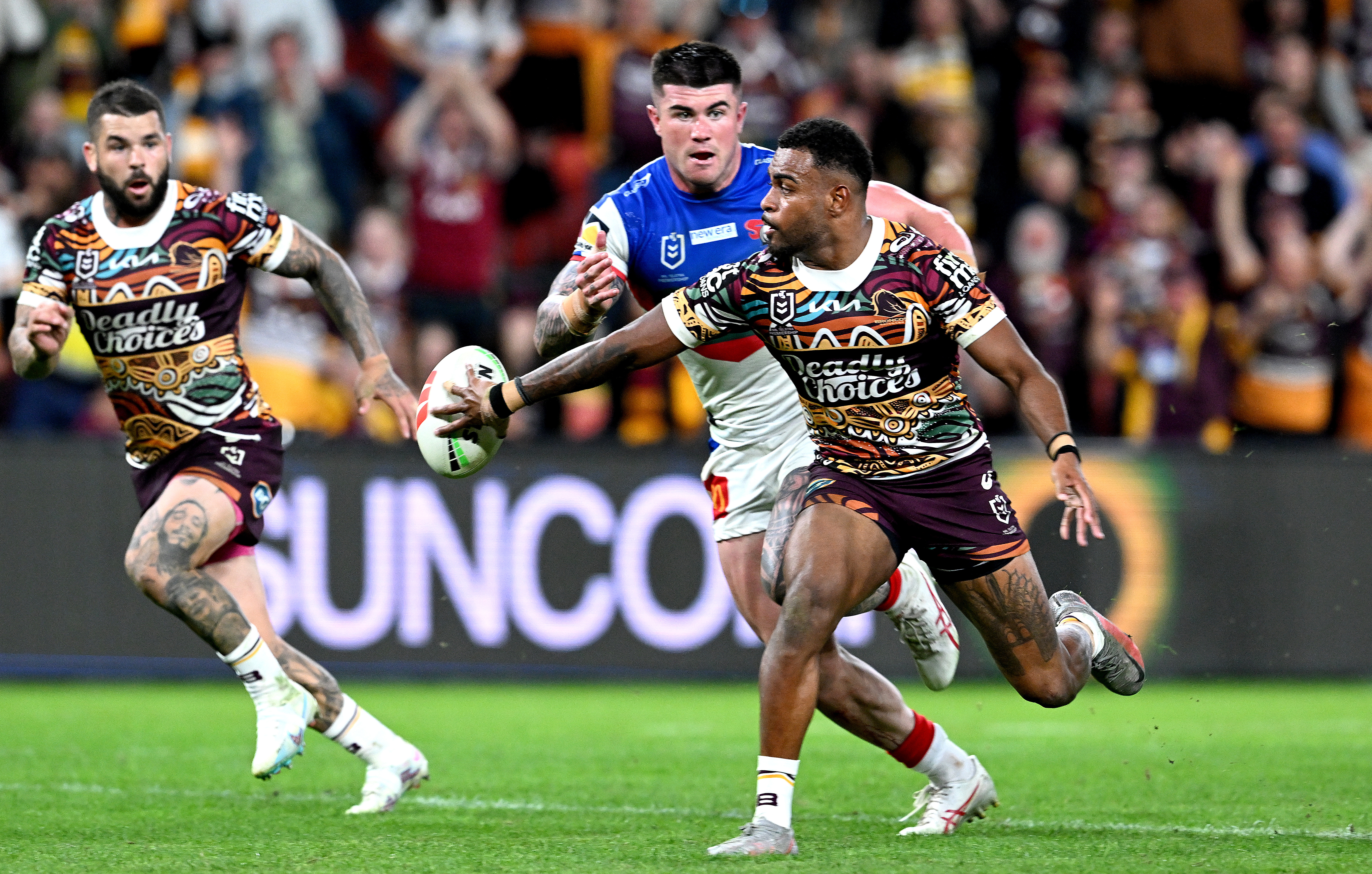Ezra Mam flick passes the ball to Broncos teammate Adam Reynolds.