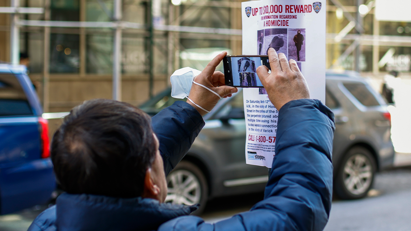 A man takes pictures of a bulletin posted by NYPD near the place where a homeless person was killed days earlier in lower Manhattan, Monday, March 14, 2022, in New York. 