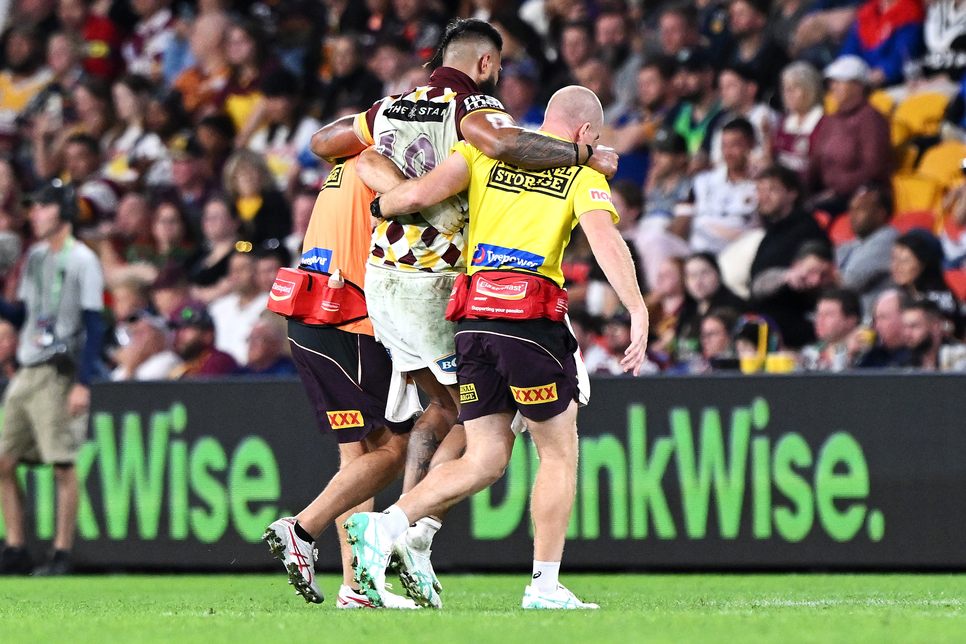 Payne Haas of the Broncos is helped from the field by the trainers.