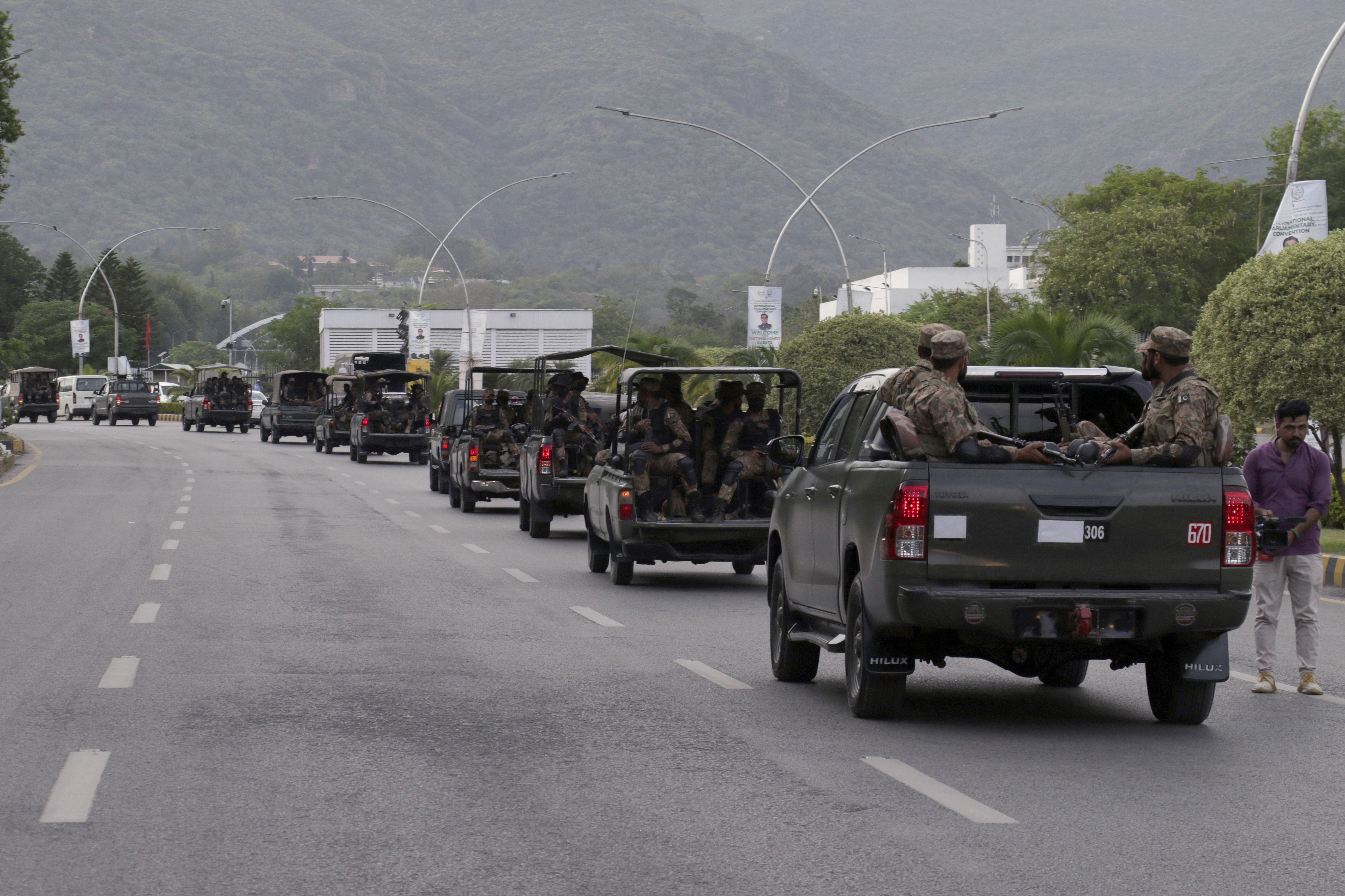 A convey of army troops patrol at a road to ensure security after clashes between police and supporters of Pakistan's former Prime Minister Imran Khan, in Islamabad, Pakistan, Thursday, May 11, 2023.