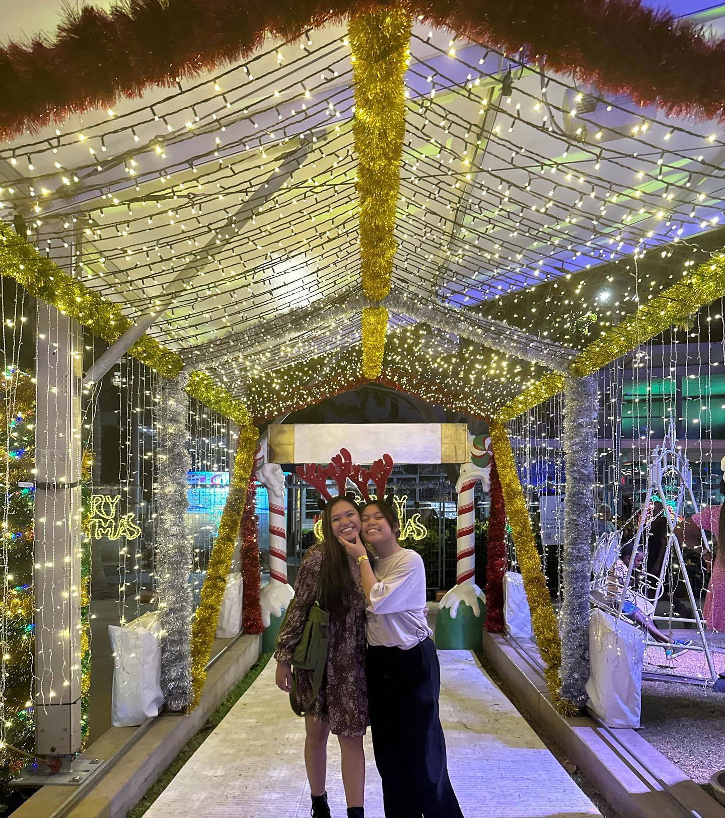 Jules and Kesh, a queer couple from Darwin, pose under fairy lights.