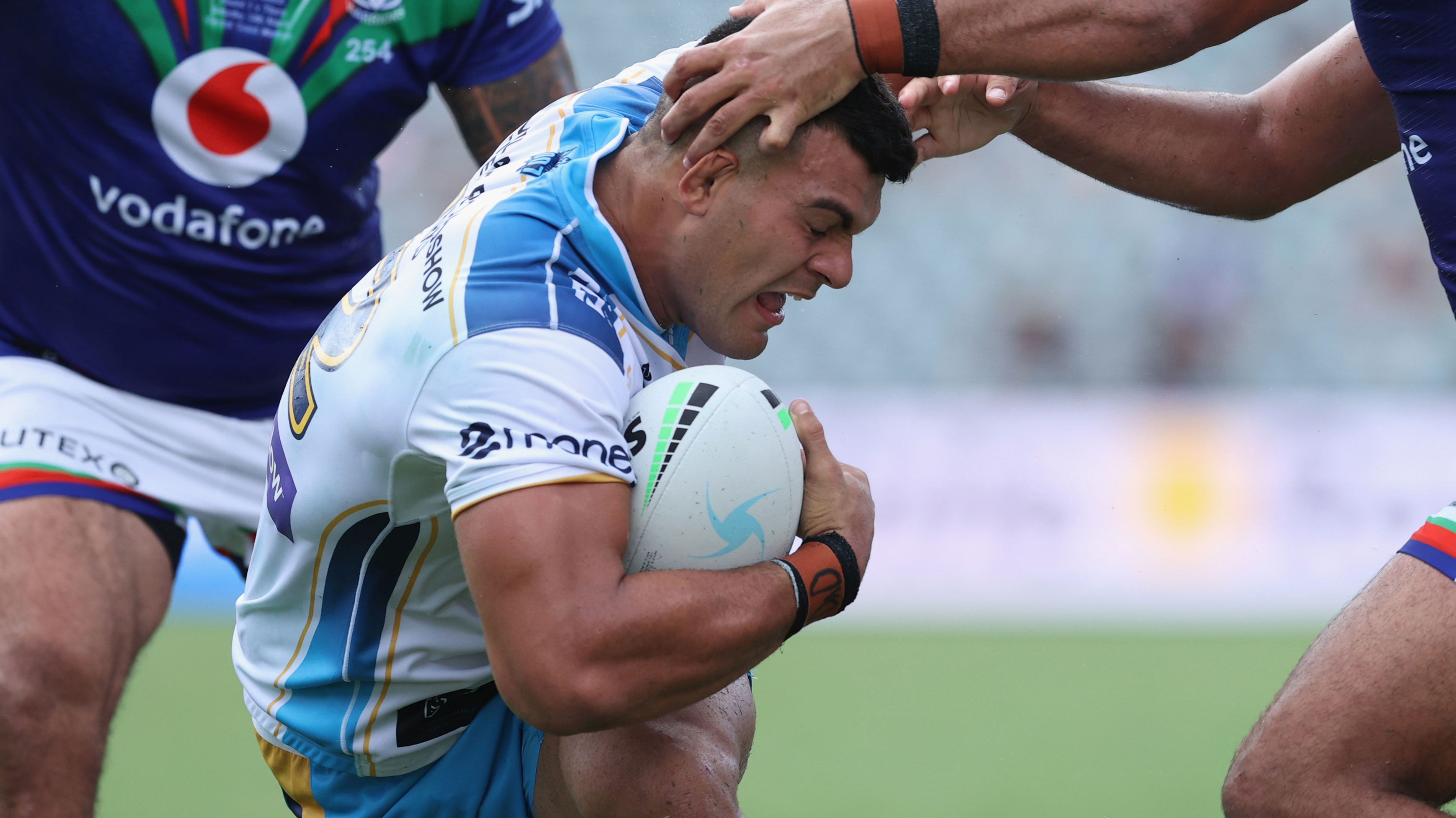 David Fifita is brought down by two Warriors tacklers.