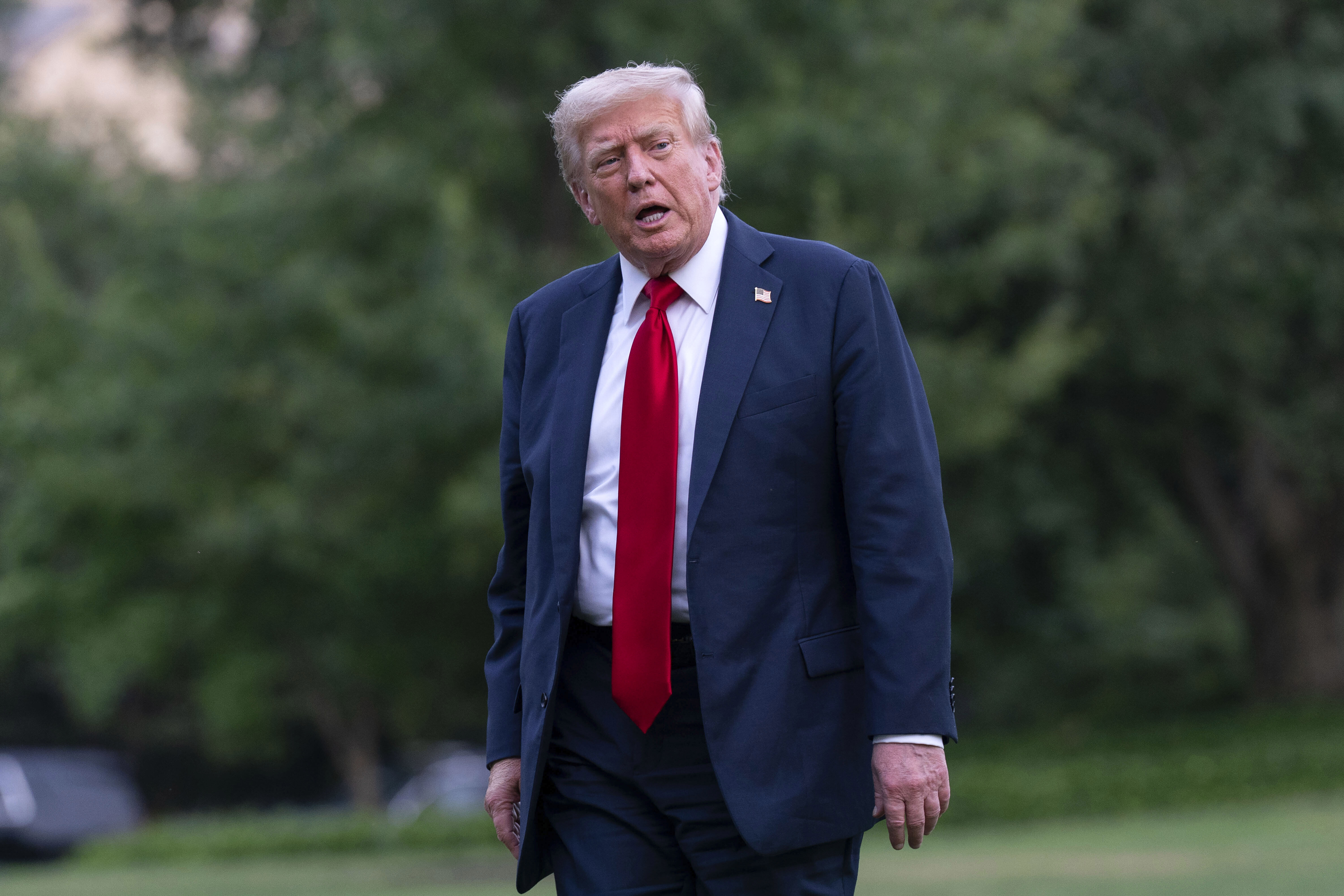 President Donald Trump talks to reporters as he walks on the South Lawn upon arriving at the White House, Sunday, July 13, 2025, in Washington. (AP Photo/Jose Luis Magana)