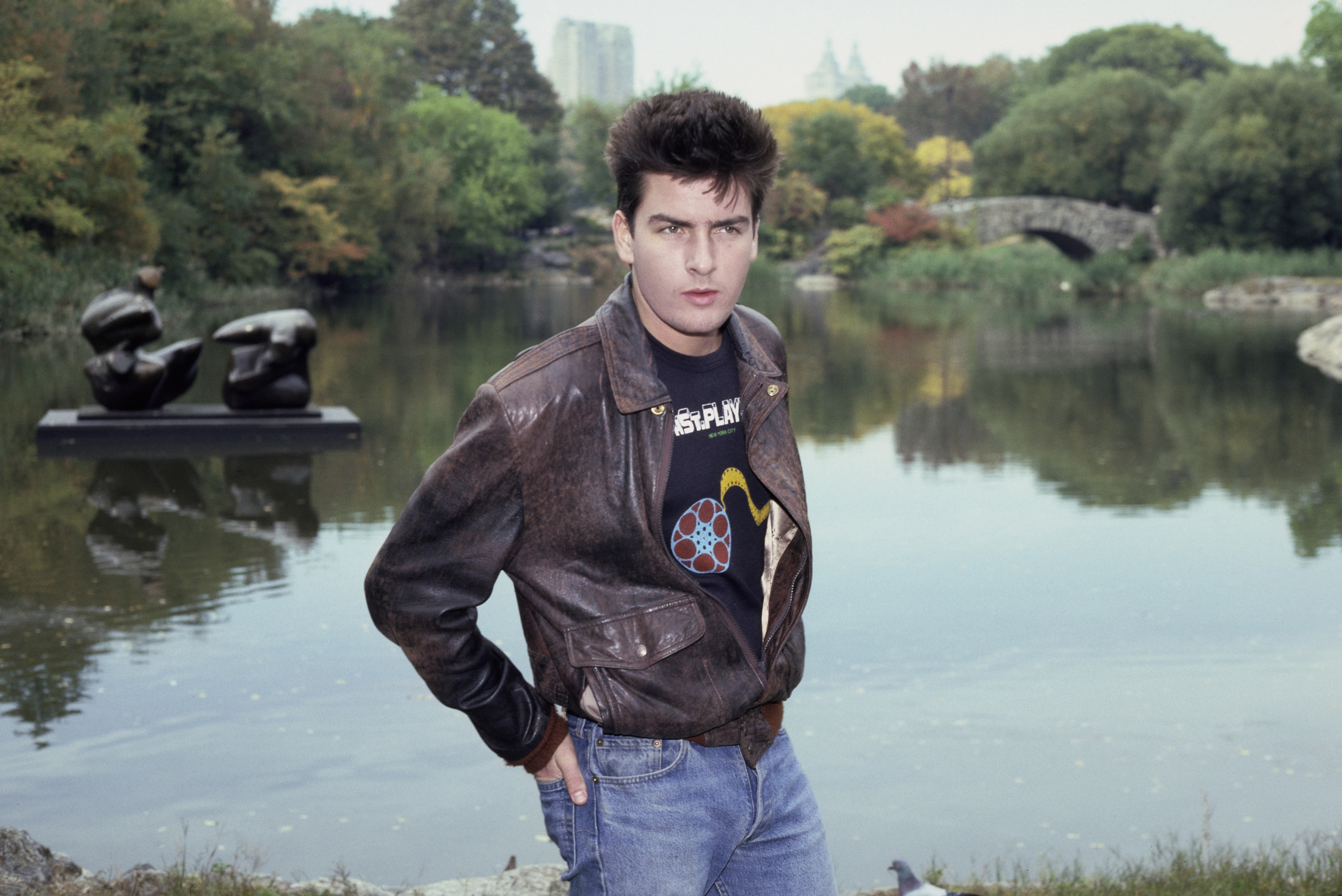 Charlie Sheen wearing a brown Type A-2 leather flight jacket and an 8th Street Playhouse t-shirt, New York City, October 1984. 