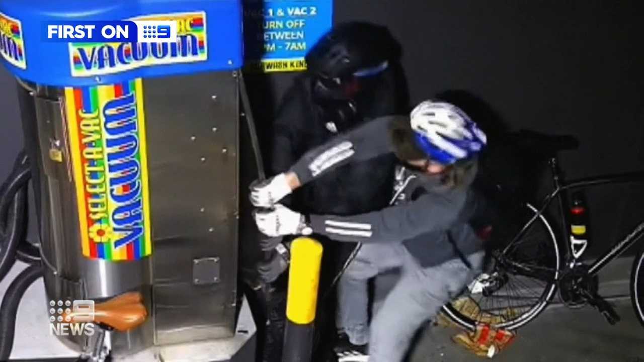 Two thieves have been caught on camera using an angle grinder to slice their way into a coin container at a car wash.