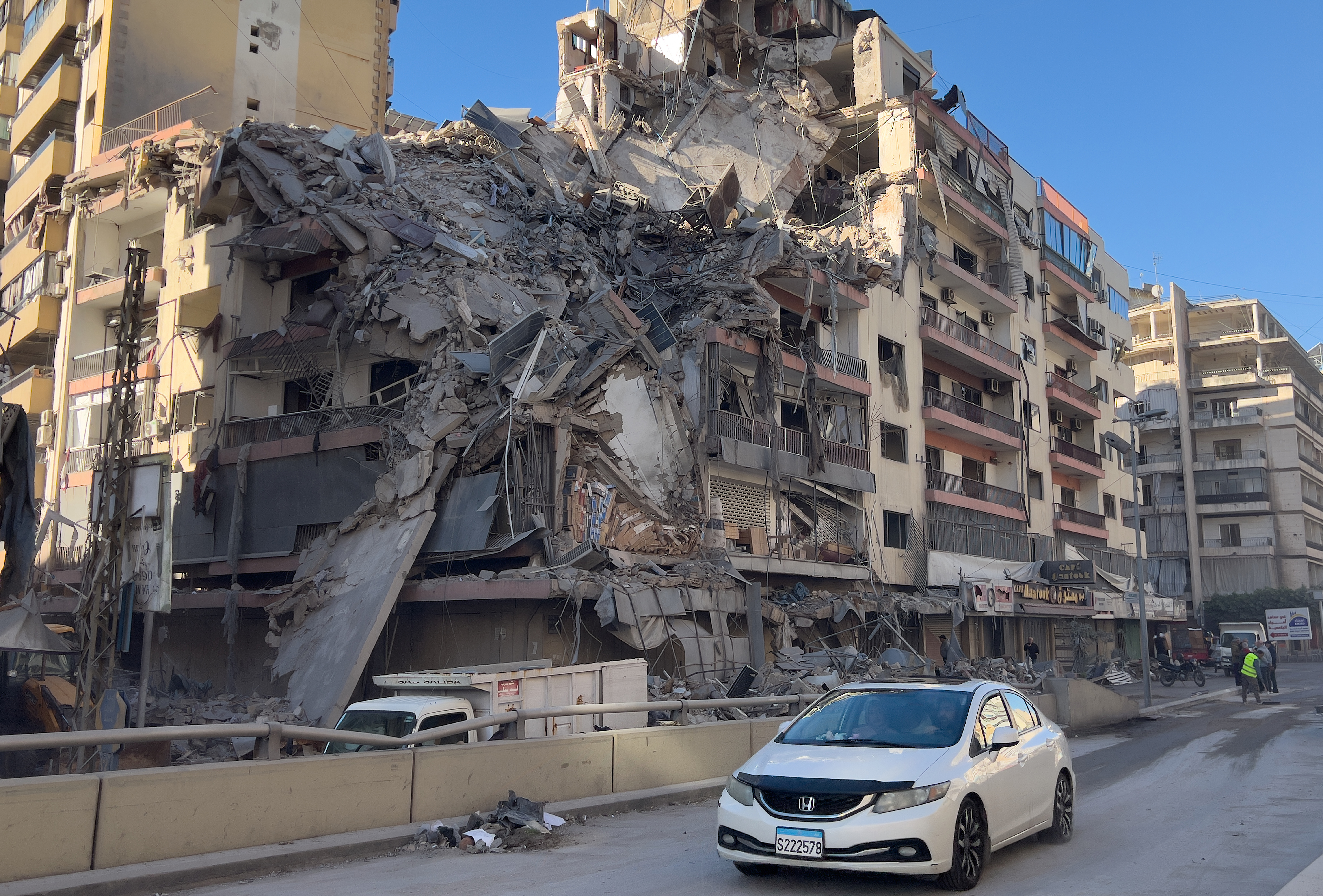 A car passes in front of a destroyed building that was hit by an Israeli airstrike in Dahiyeh, Beirut's southern suburbs, Lebanon, Thursday, March 5, 2026. (AP Photo/Hussein Malla)