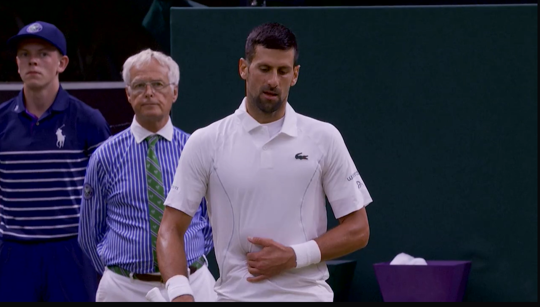 Novak Djokovic clutches at his abs. 