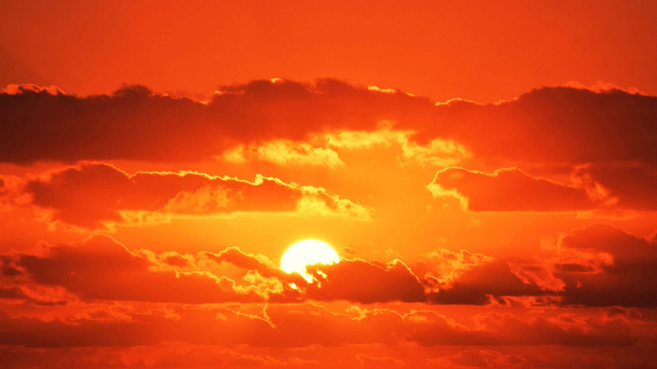 The sun turns the early morning sky red as it breaks through clouds on Queensland's Gold Coast.
