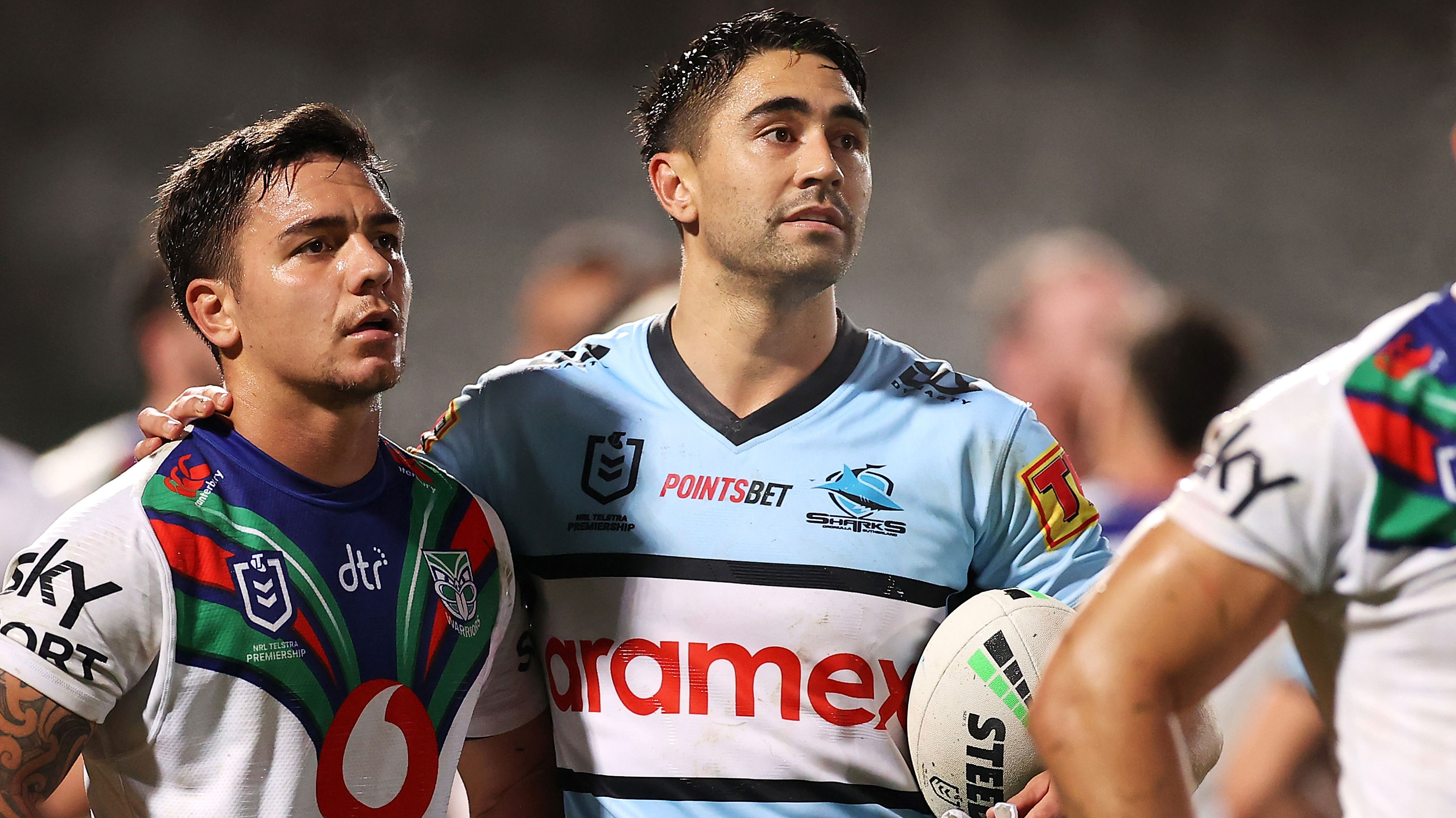 The Warriors' Kodi Nikorima and Sharks star Shaun Johnson watch the big screen as a try is reviewed.