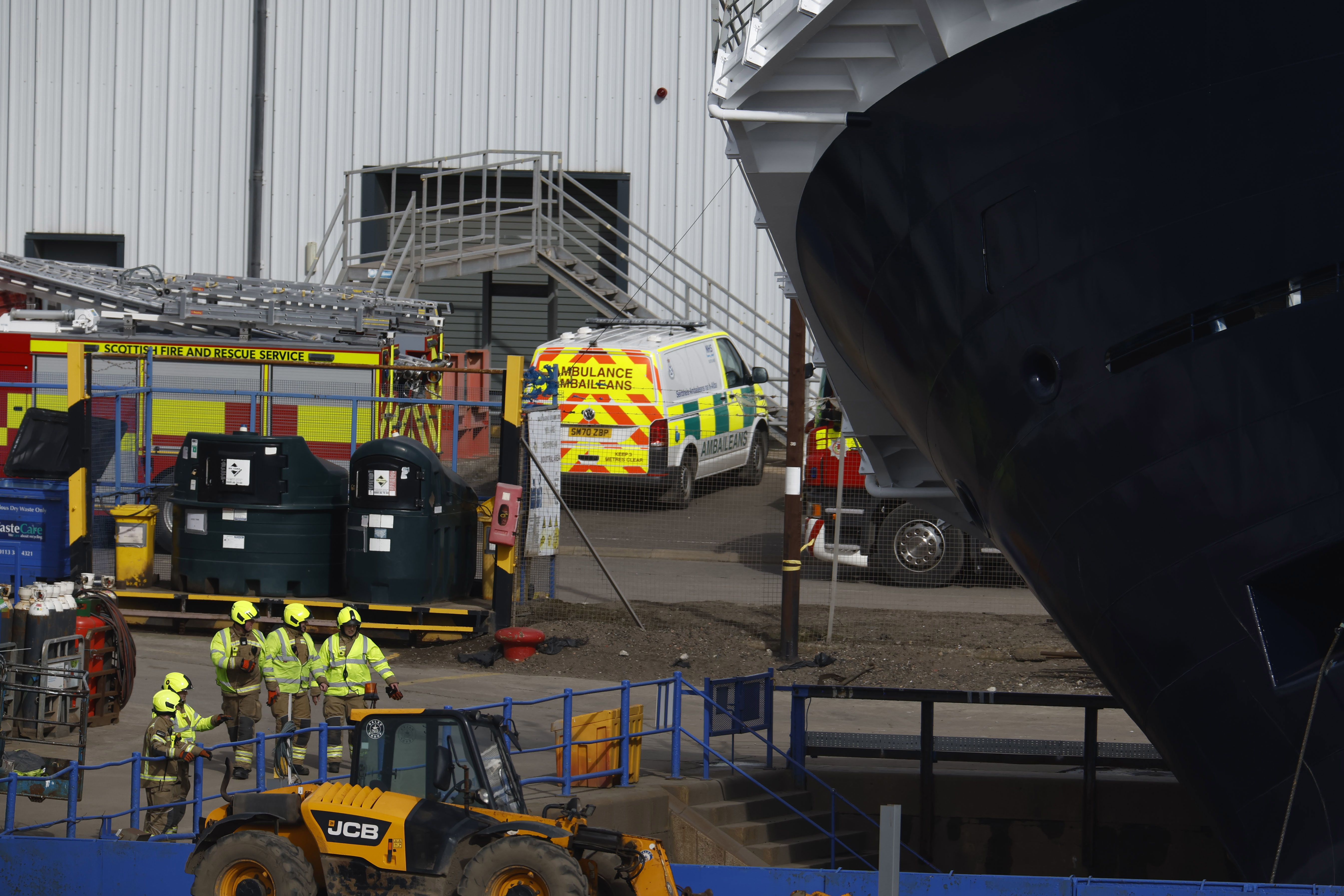 Emergency teams attend the scene after a ship tipped over at a 45-degree angle in the Imperial Dock area in Leith on March 22, 2023 in Leith, Scotland.