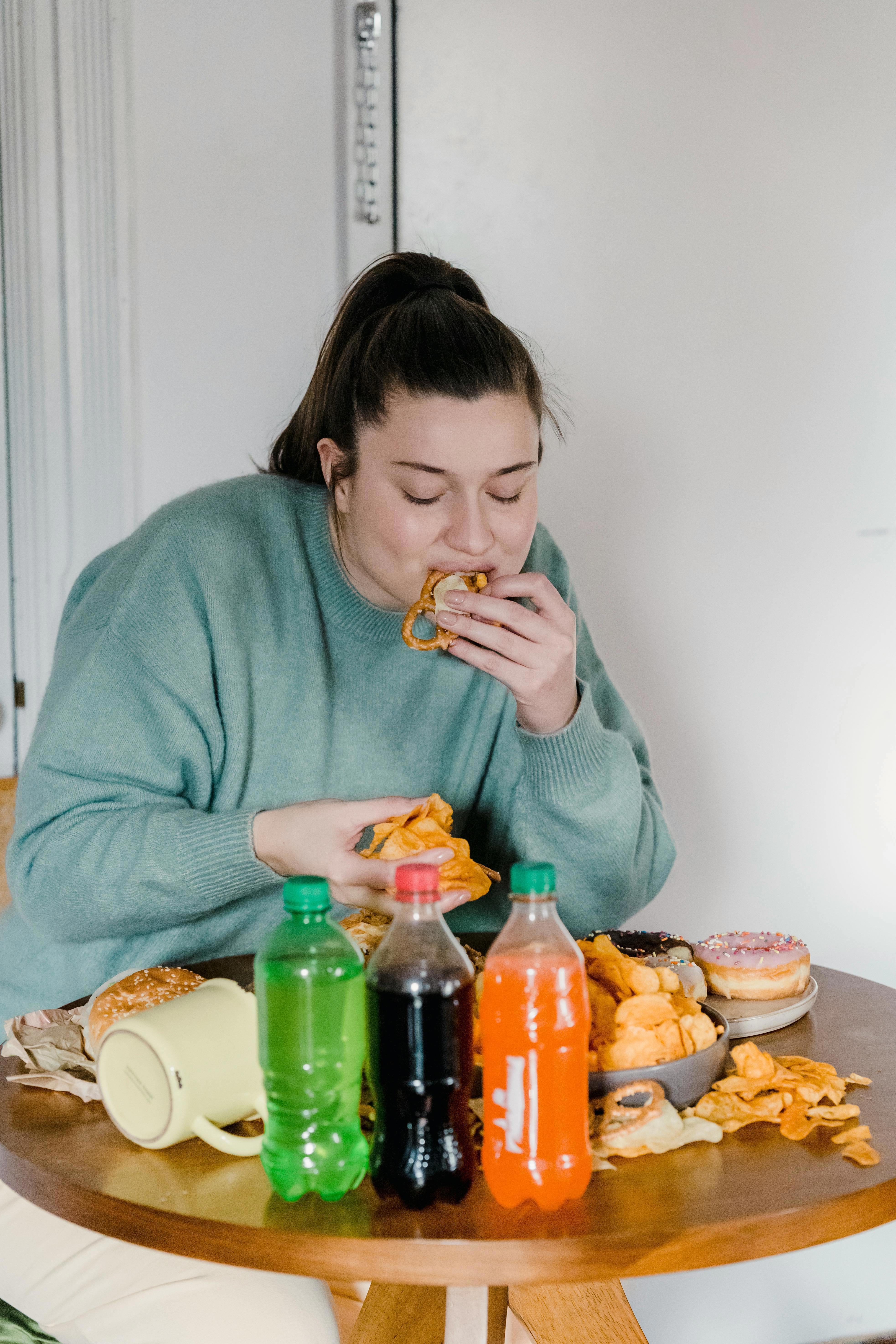 Stock image of a woman eating junk food.