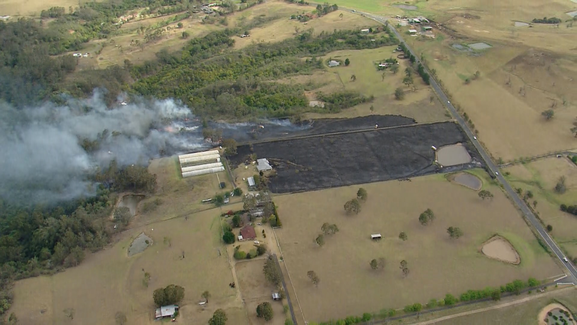 F﻿irefighters are working to extinguish a bushfire that is believed to be threatening homes in Sydney's south west at The Oaks