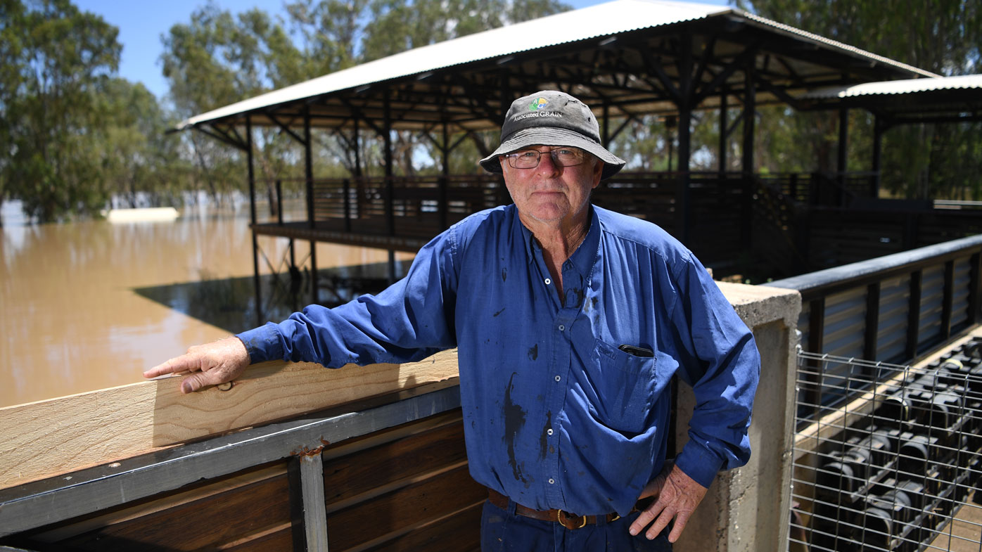 Peter Goodwin poses for a photo with his flooded back yard seen in the background, adjacent to the Balonne river in St George, south-western Queensland, Thursday, February 27, 2020. The Balonne river has peaked at 12.2 metres, causing local flooding.