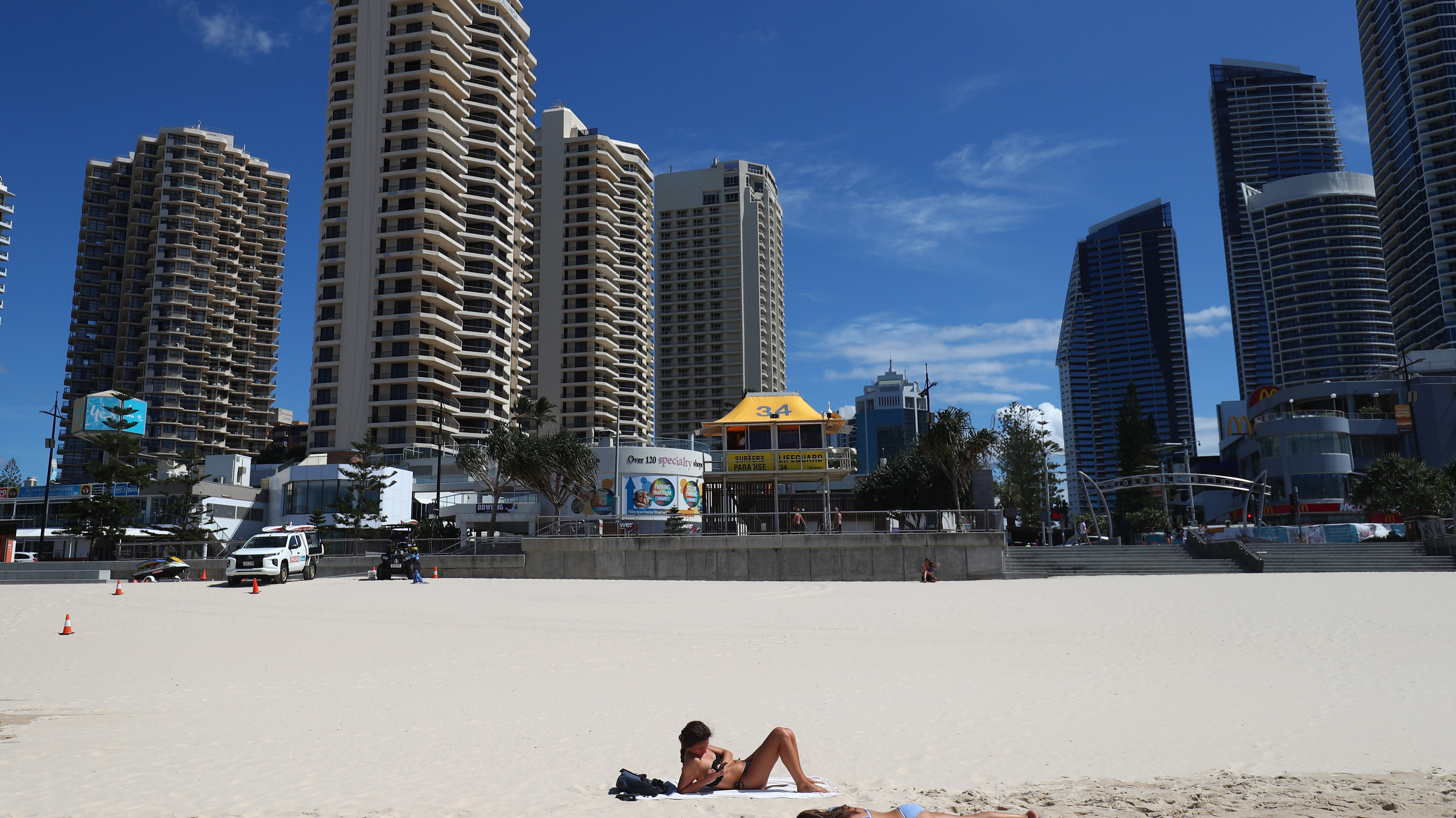 People lie on the beach at Surfers Paradise in Gold Coast, Australia. 