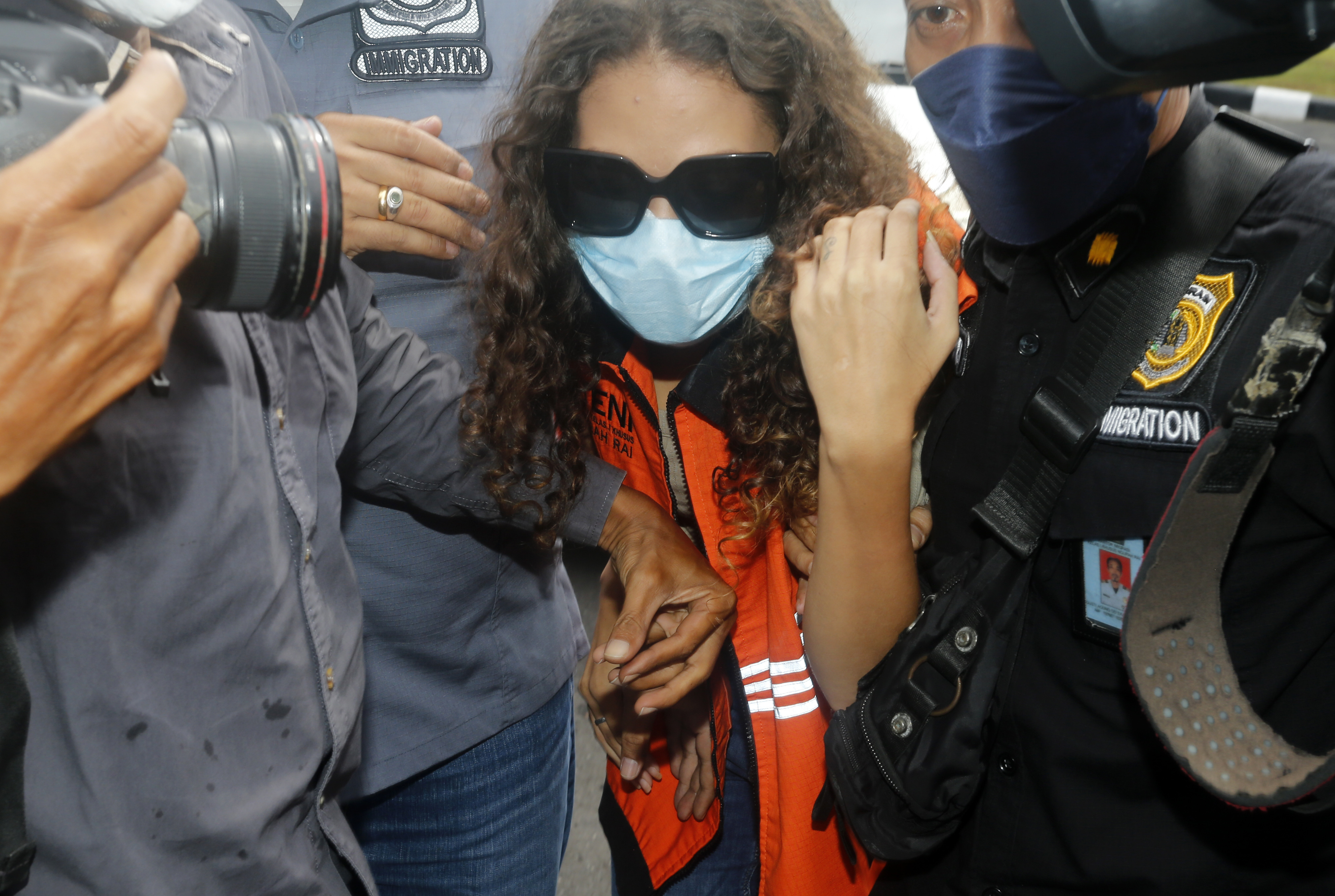 Heather Mack of Chicago, Ill., centre, escorted by immigration officers to Immigration detention centre in Jimbaran, Bali, Indonesia on Friday, Oct. 29, 2021. 