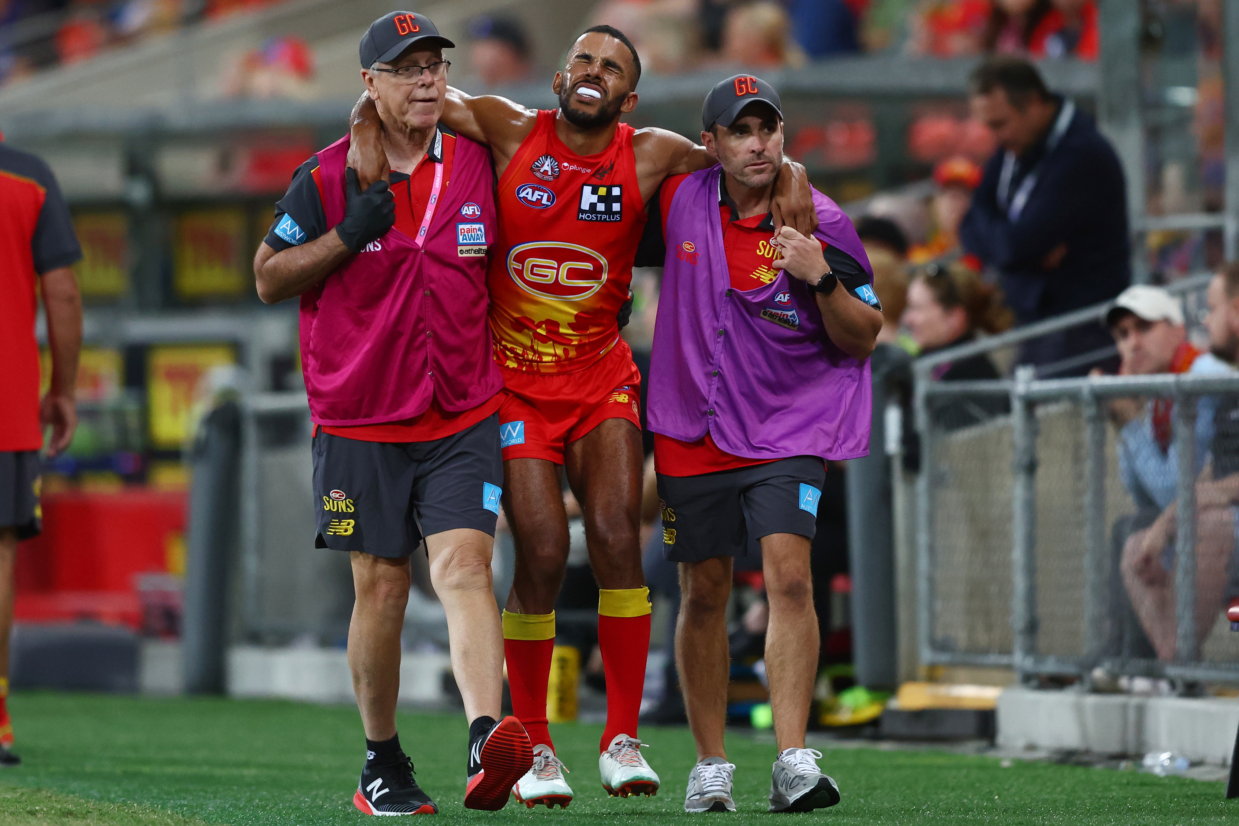 GOLD COAST, AUSTRALIA - APRIL 23: Touk Miller of the Suns is helped from the field during the round six AFL match between Gold Coast Suns and North Melbourne Kangaroos at Heritage Bank Stadium, on April 23, 2023, in Gold Coast, Australia. (Photo by Chris Hyde/Getty Images)