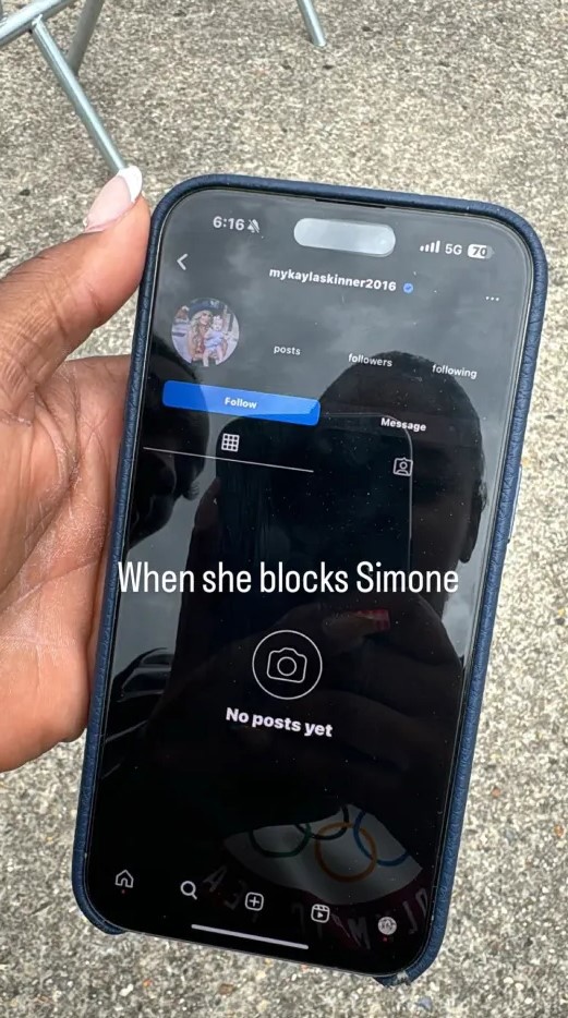 Joran Chiles and Simone Biles are seen in the reflection of the phone