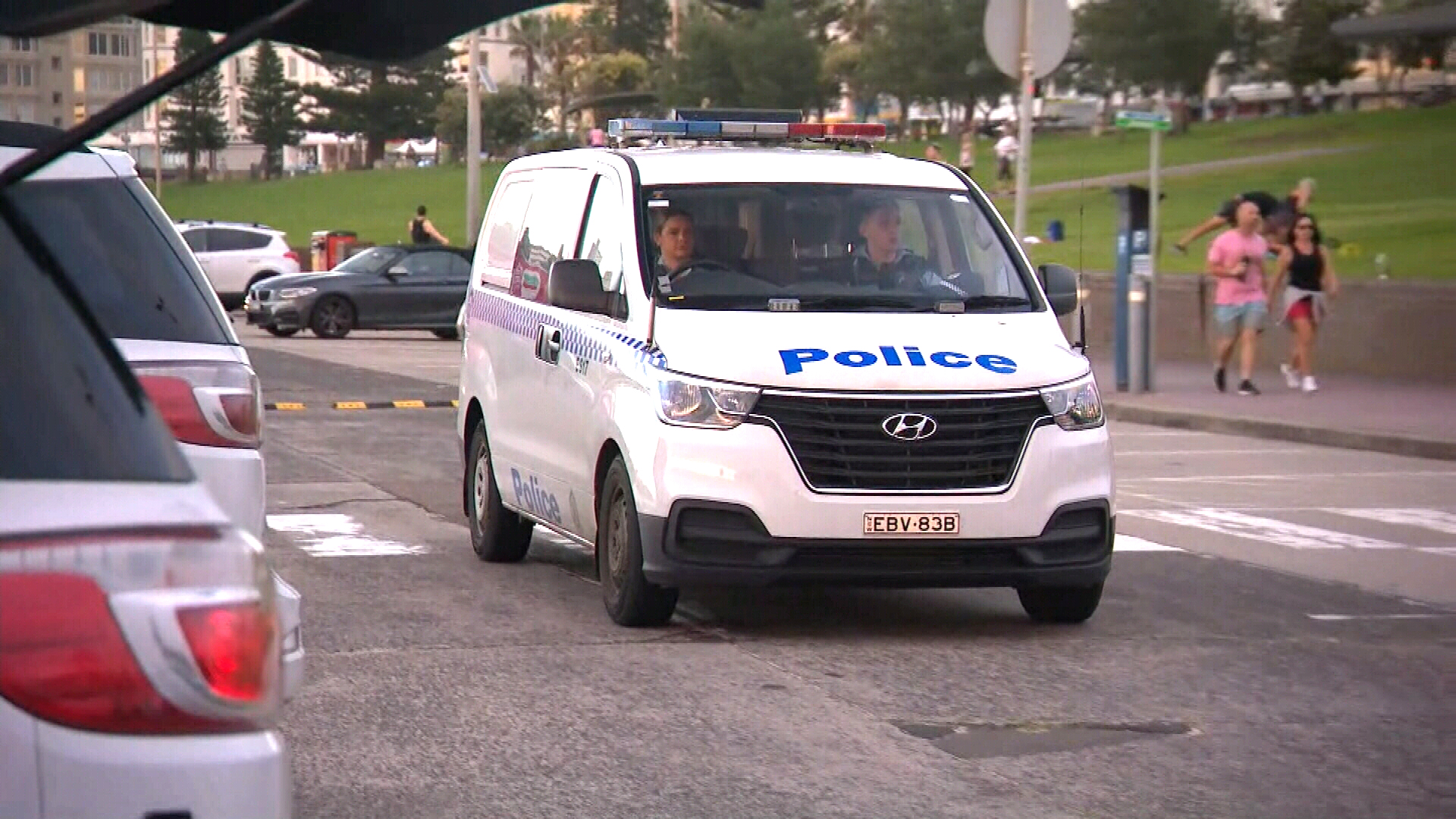 A NSW Police van drives through a Bondi Beach carpark. Around 70,000 police officers are patrolling the social distancing orders.