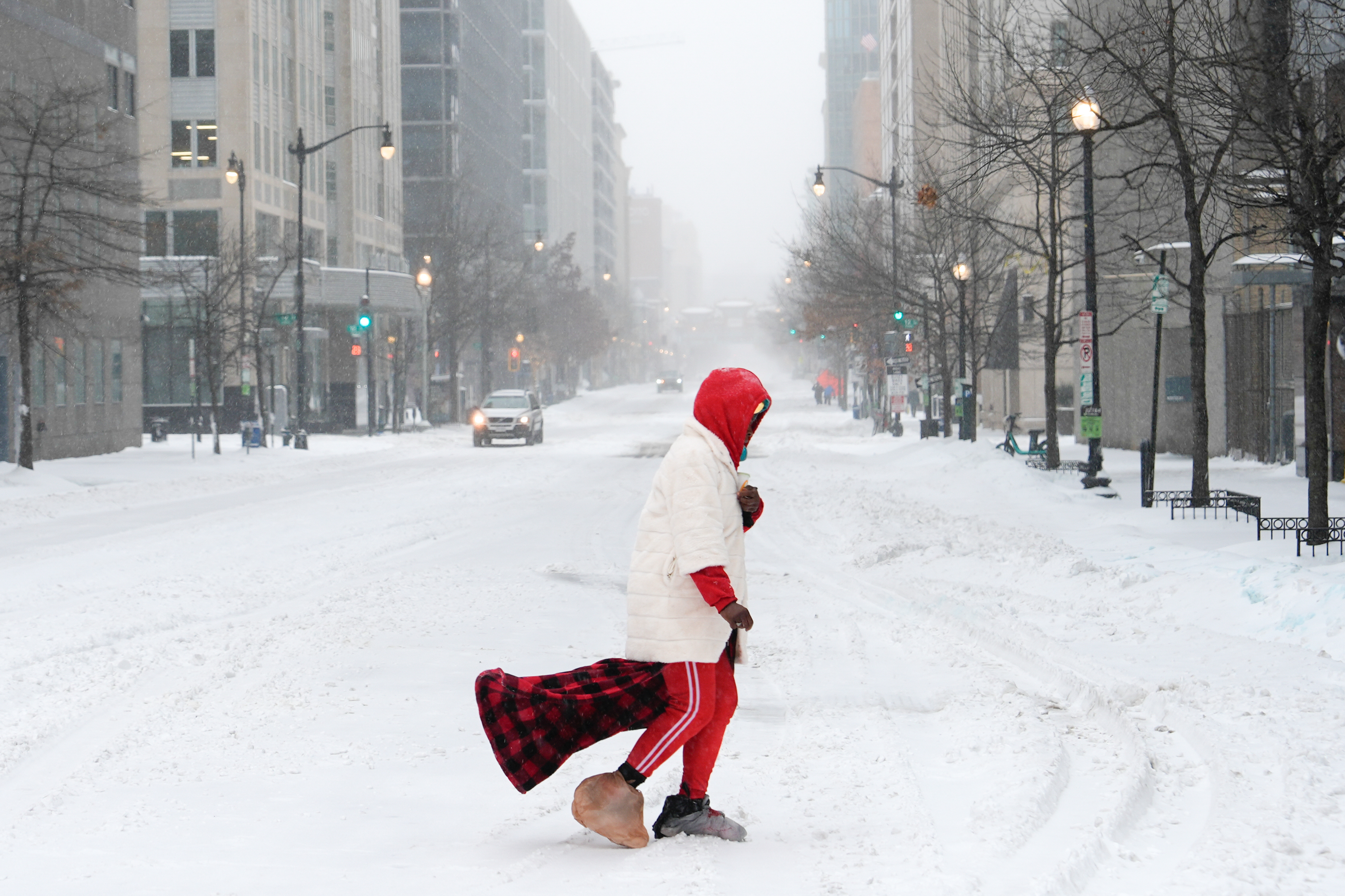 A person crosses a street during a snowstorm, Sunday, Jan. 25, 2026, in Washington. (AP Photo/Julia Demaree Nikhinson)