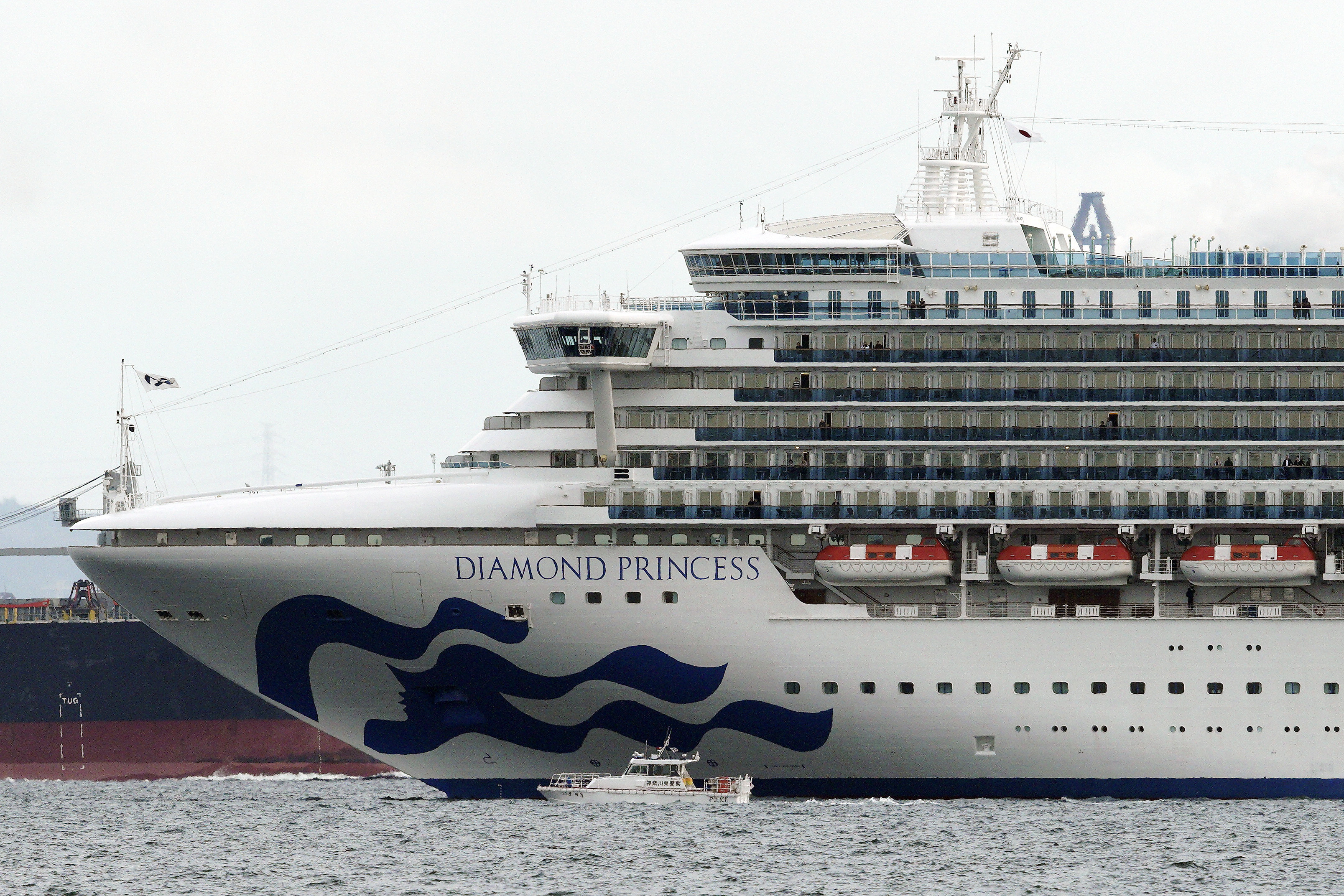 A small boat navigates near a cruise ship Diamond Princess anchoring off the Yokohama Port in Yokohama, near Tokyo. 
