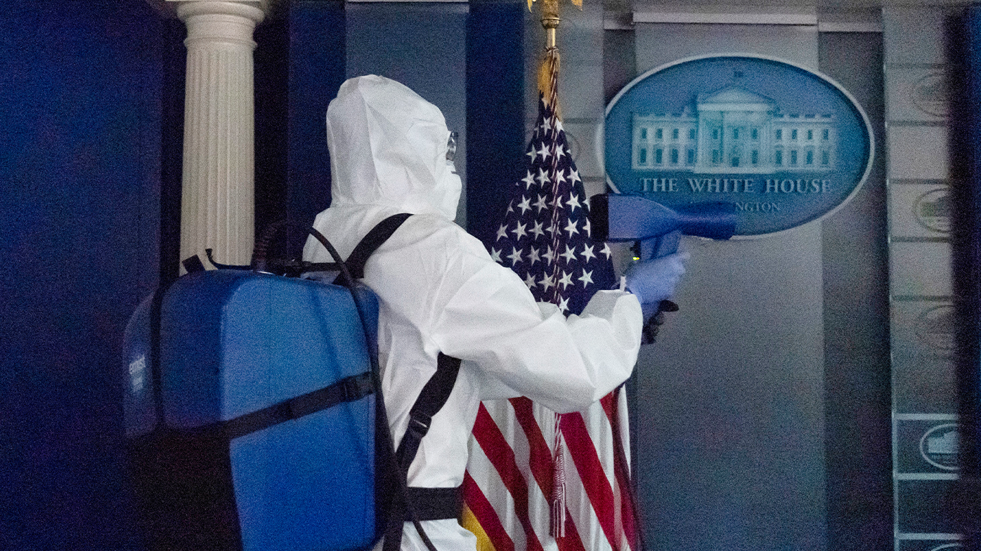 A member of the cleaning staff sprays The James Brady Briefing Room of the White House, Monday, Oct. 5, 2020, in Washington. (AP Photo/Alex Brandon)