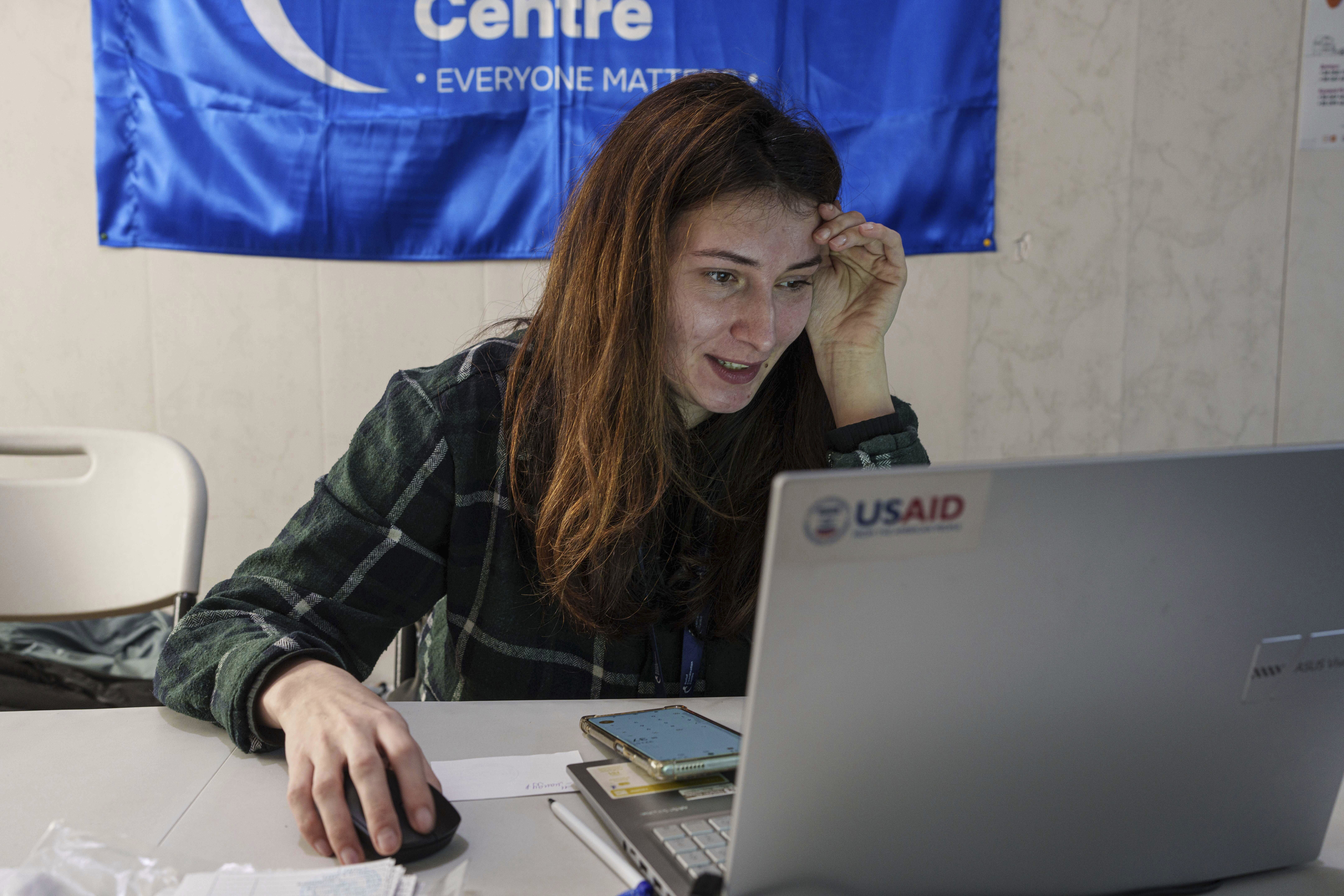 A social worker looks at a laptop with a USAID logo, at a centre for displaced people in Pavlohrad, Ukraine, Saturday, Feb. 1, 2024. 
