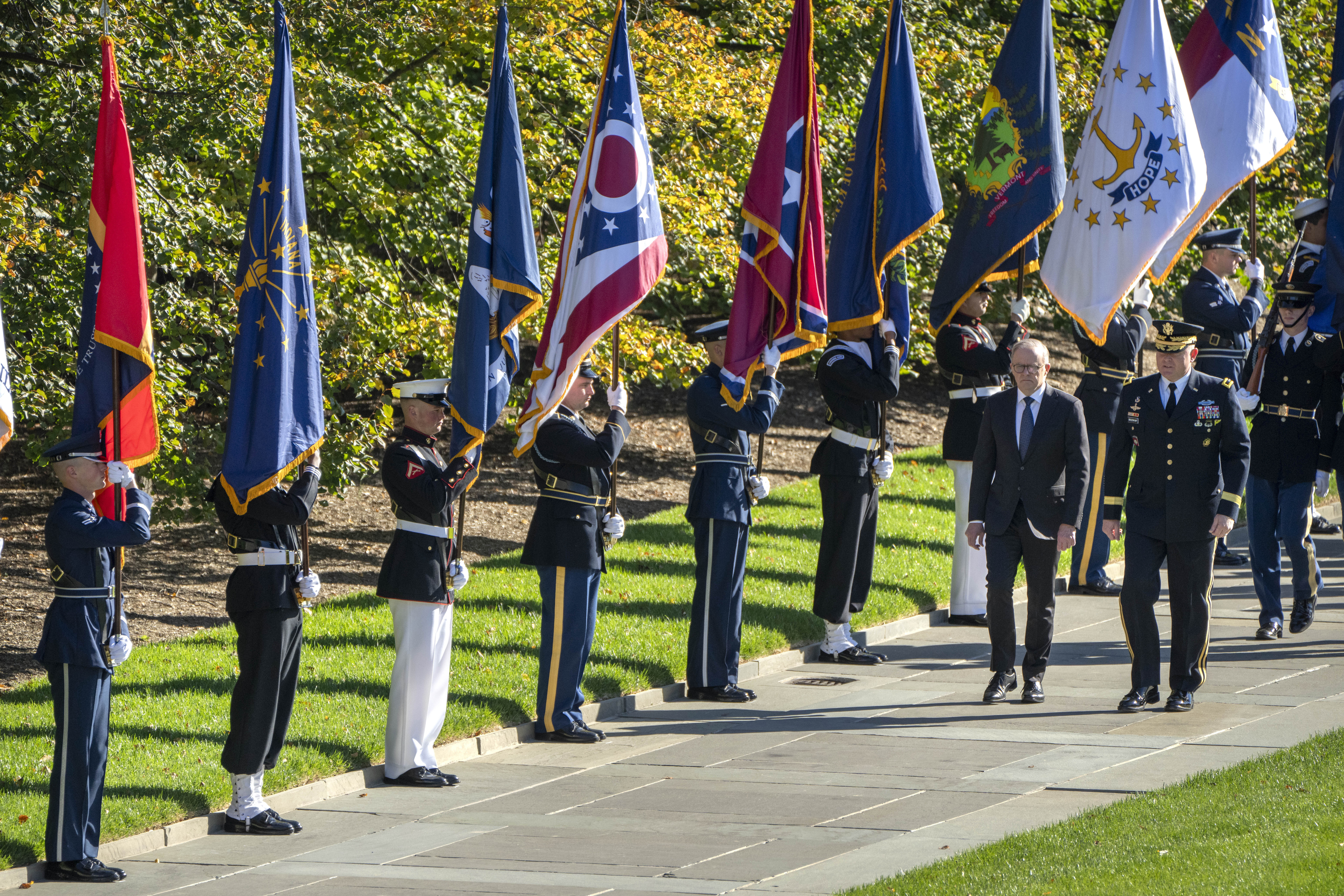 Australian Prime Minister Anthony Albanese, second from right, and Maj. Gen. Trevor Bredenkamp, right, commanding general, Joint Task Force-National Capital Region and the U.S. Army Military District of Washington, walk past flagbearers holding U.S. state flags during a ceremony at the Tomb of the Unknown Solider at Arlington National Cemetery Monday, Oct. 23, 2023, in Arlington, Va.