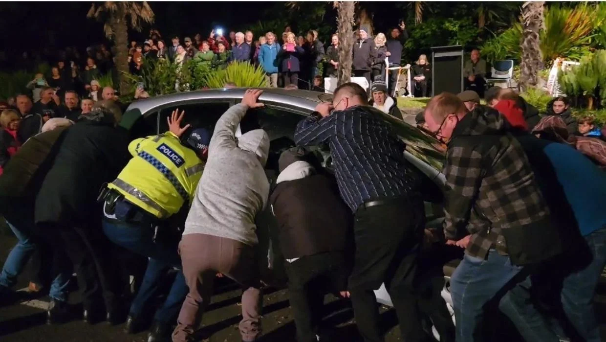 Crowd lifts car out of the way of Anzac ceremony in New Plymouth New Zealand