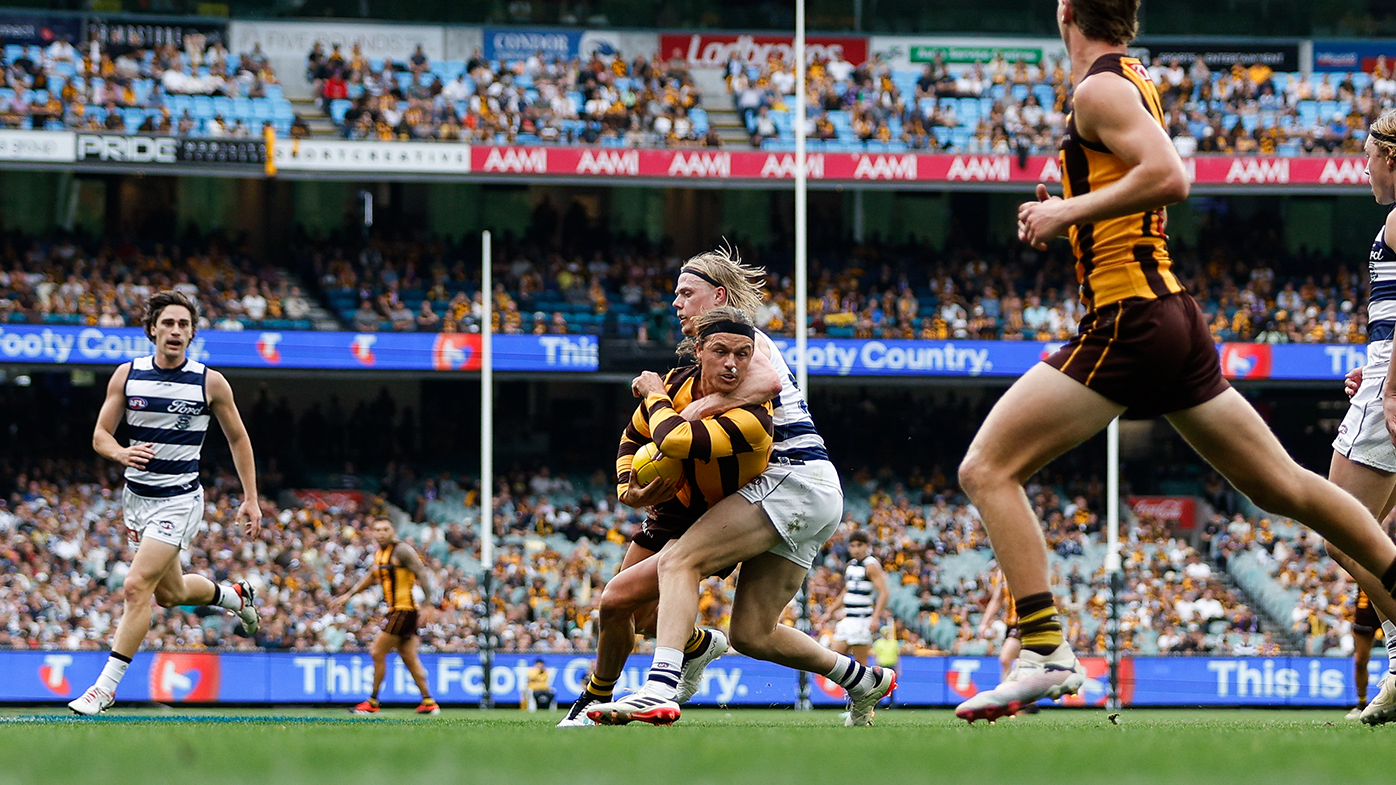 Jack Ginnivan of the Hawks is tackled high by Zach Guthrie of the Cats during their round three clash.