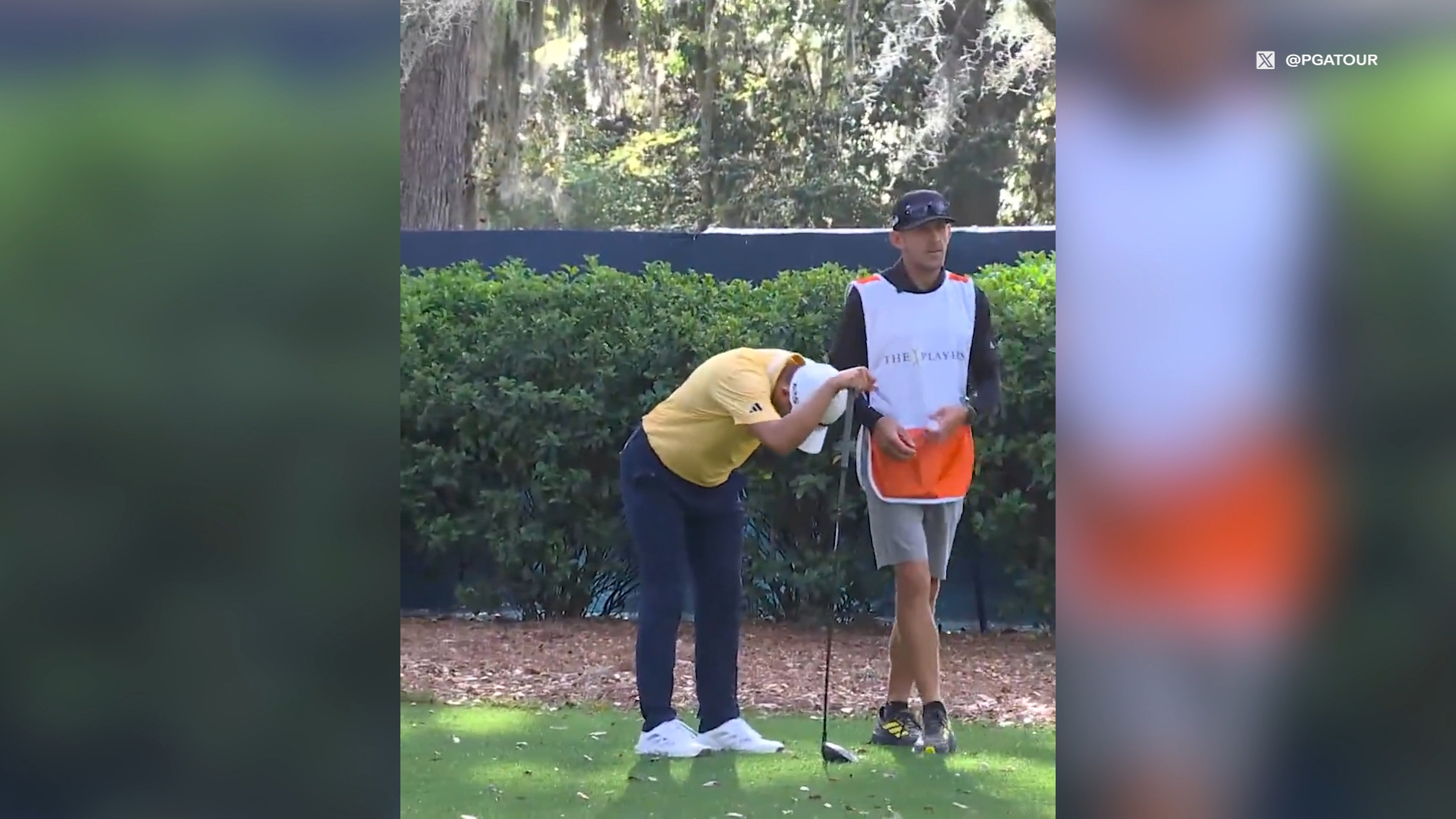 Collin Morikawa grabs at his lower back.