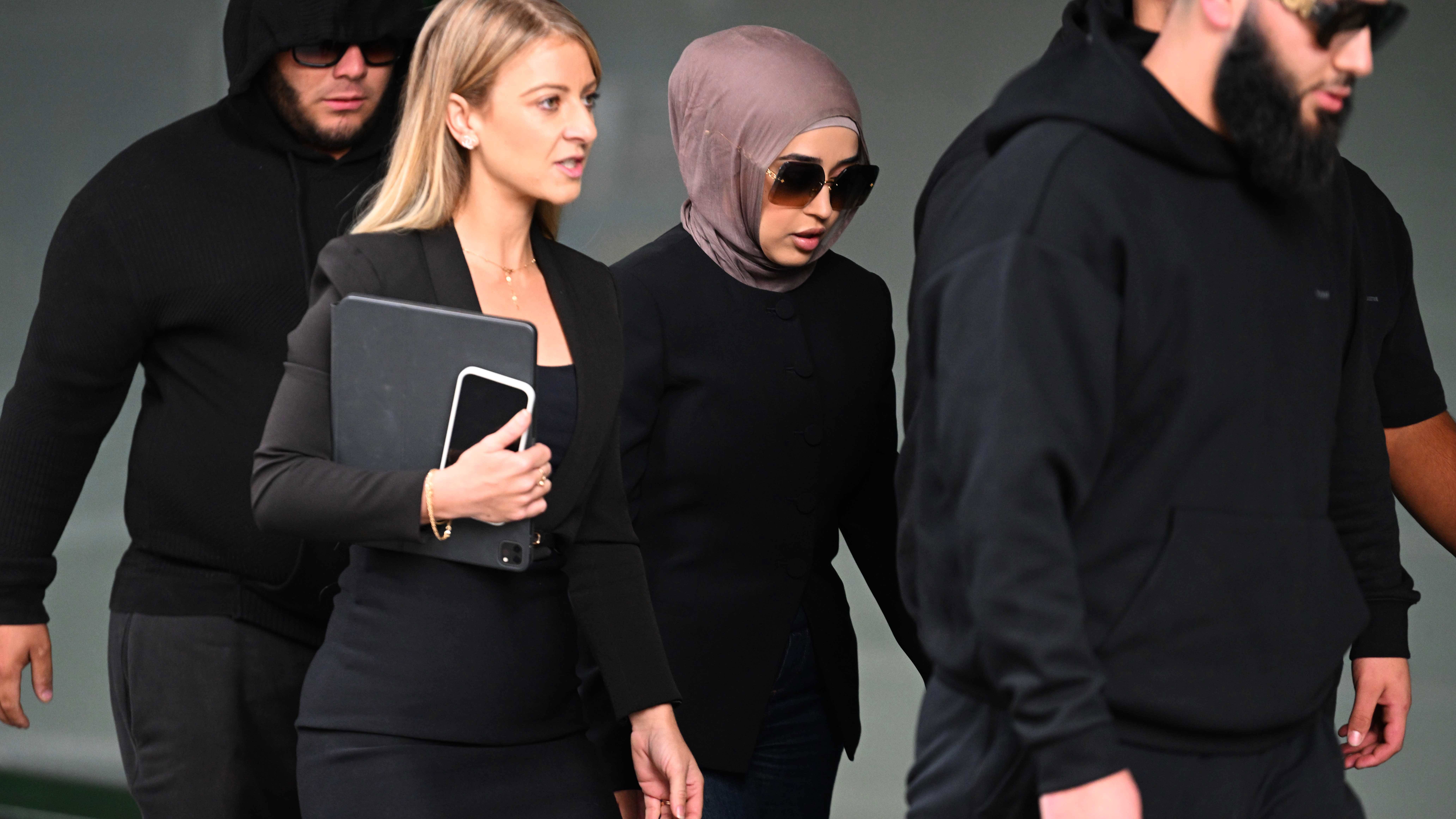 New South Wales health former nurse Sarah Abu Lebdeh arrives surrounded by supporters at the Downing Centre local court in Sydney