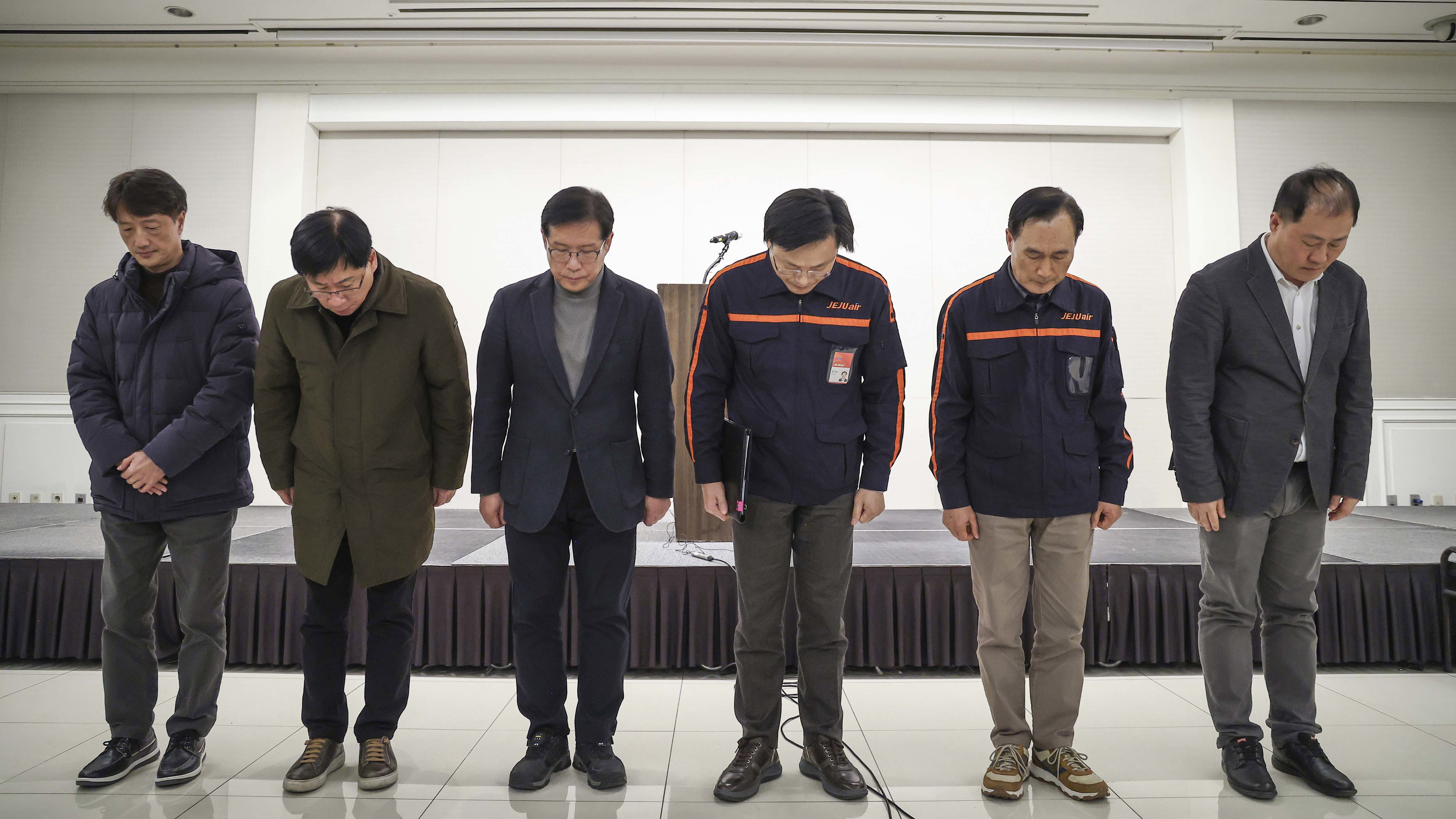 Jeju Air CEO Kim E-bae, fourth from left, and other executive members bow in apology ahead of a briefing in Seoul, South Korea, Sunday, Dec. 29, 2024 after its passenger plane burst into flames at an airport in the town of Muan