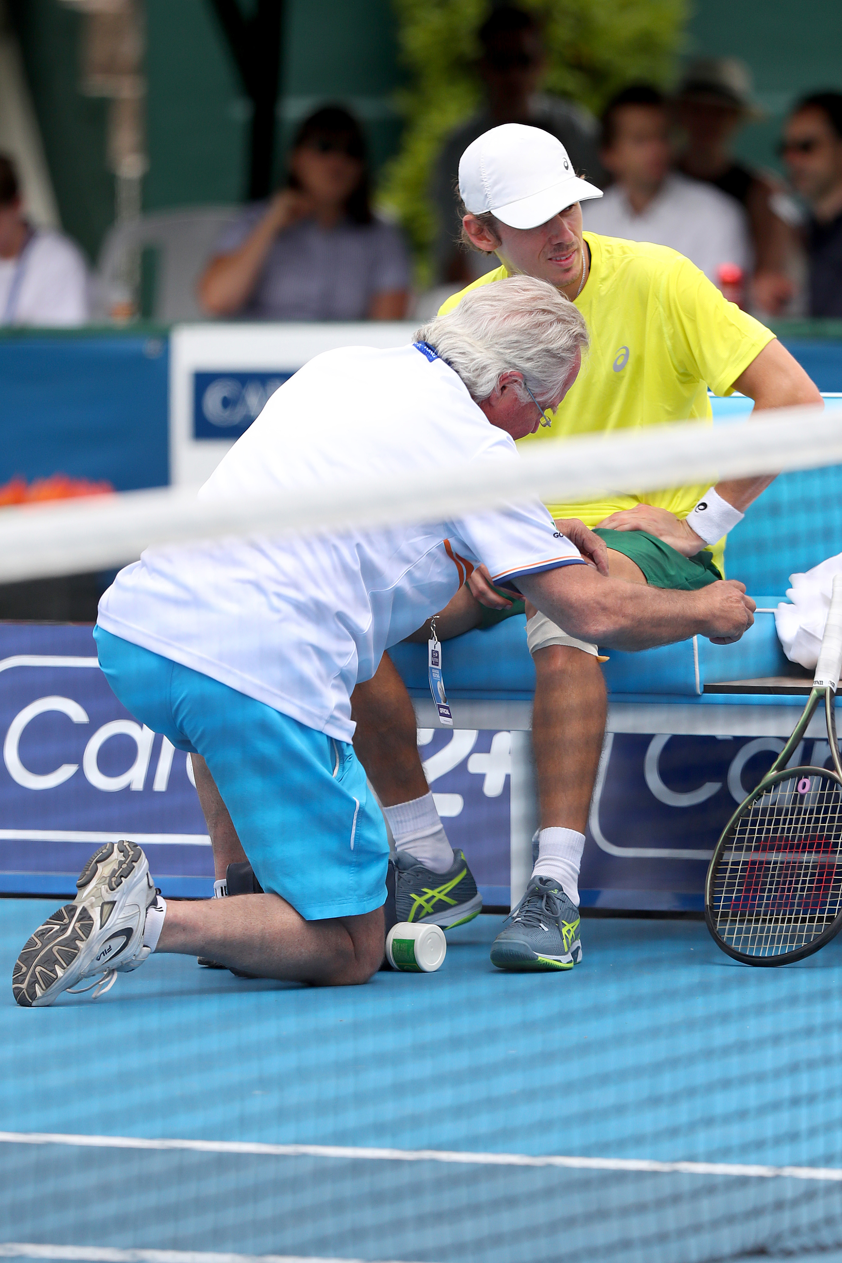 Alex de Minaur of Australia receives attention from a trainer.