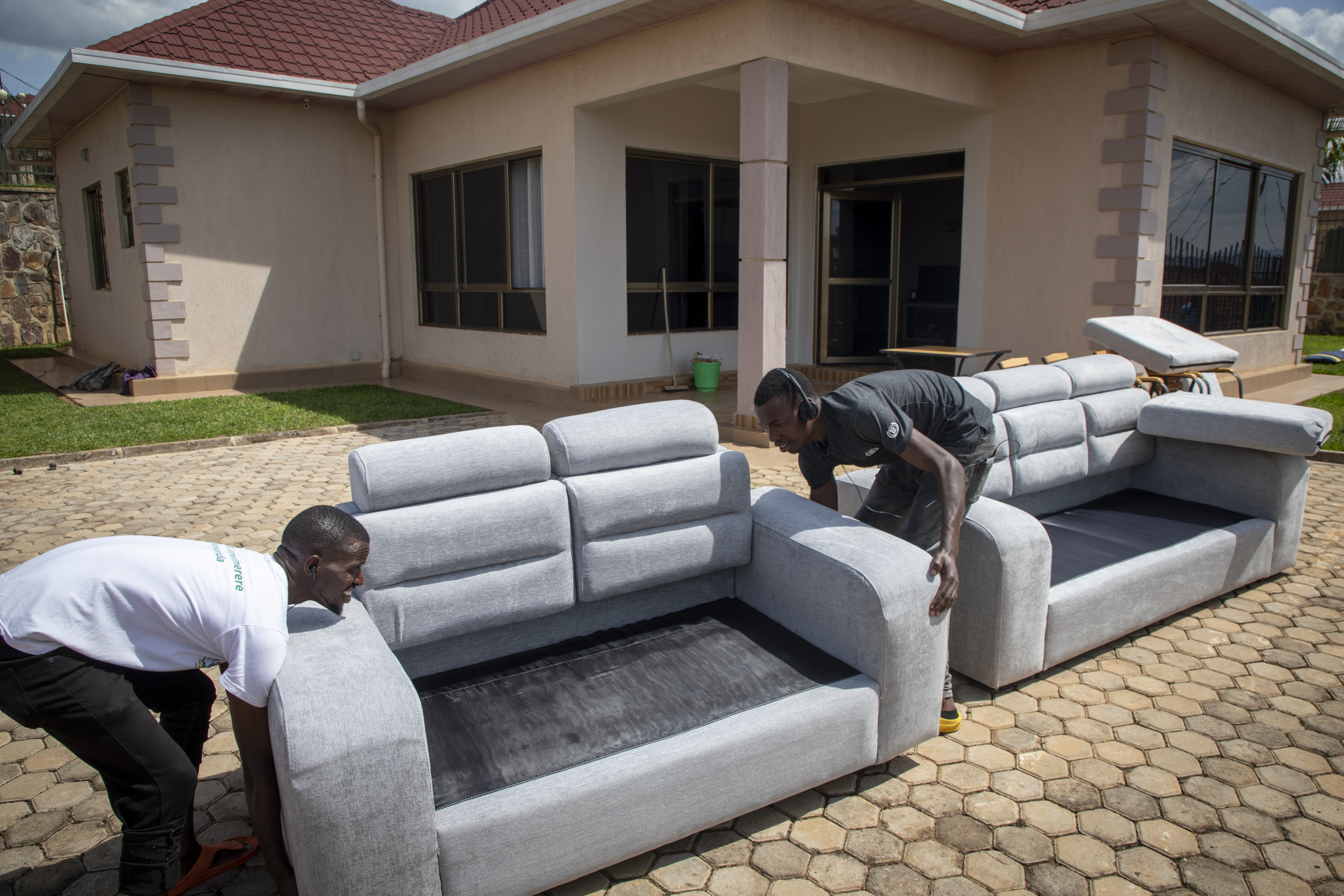 FILE - People carry furniture into the newly refurbished Hallmark Residences, which is one of the locations expected to house some of the asylum-seekers due to be sent from Britain to Rwanda, in the capital Kigali, Rwanda on May 19, 2022. A group of asylum-seekers asked a U.K. court on Friday, June 10, 2022 to stop the British government sending them on a one-way flight to Rwanda. (AP Photo/File)