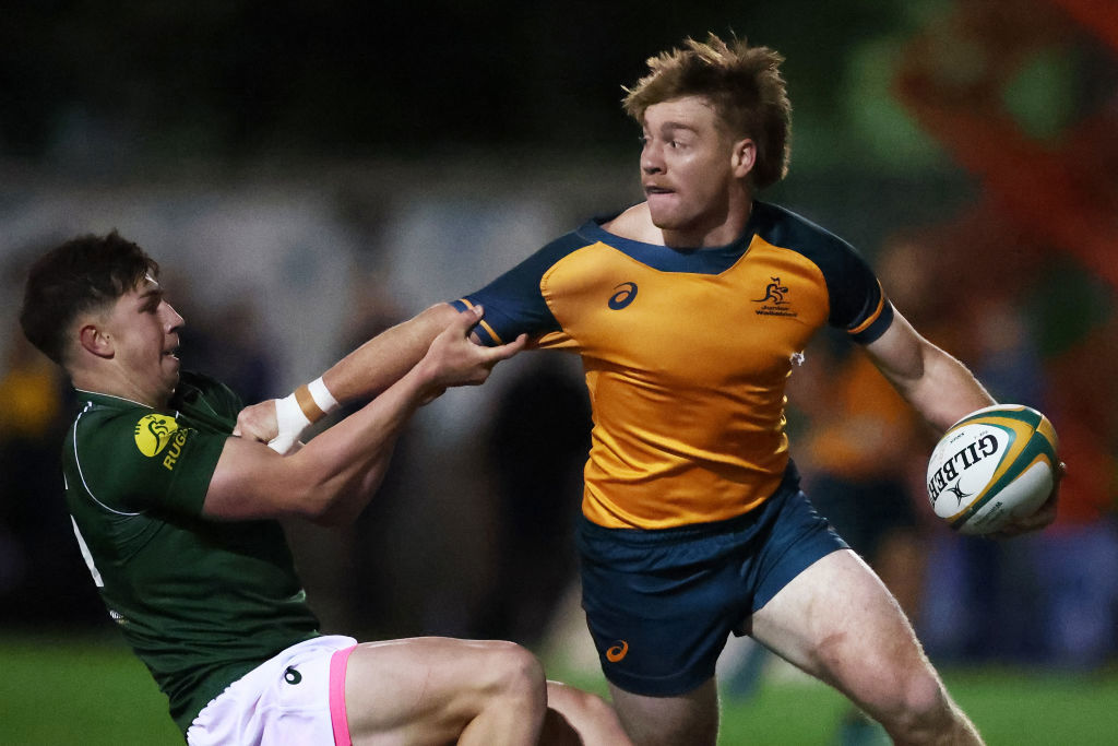 Harry McLaughlin-Phillips of the Junior Wallabies is tackled at David Phillips Field.