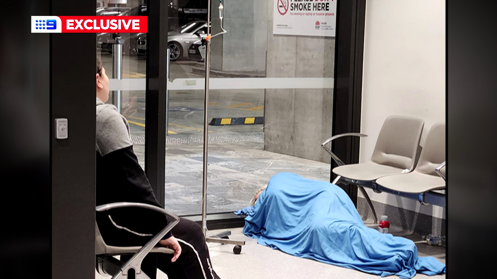 A sick patient receiving fluid intravenously on the floor of Westmead Hospital.