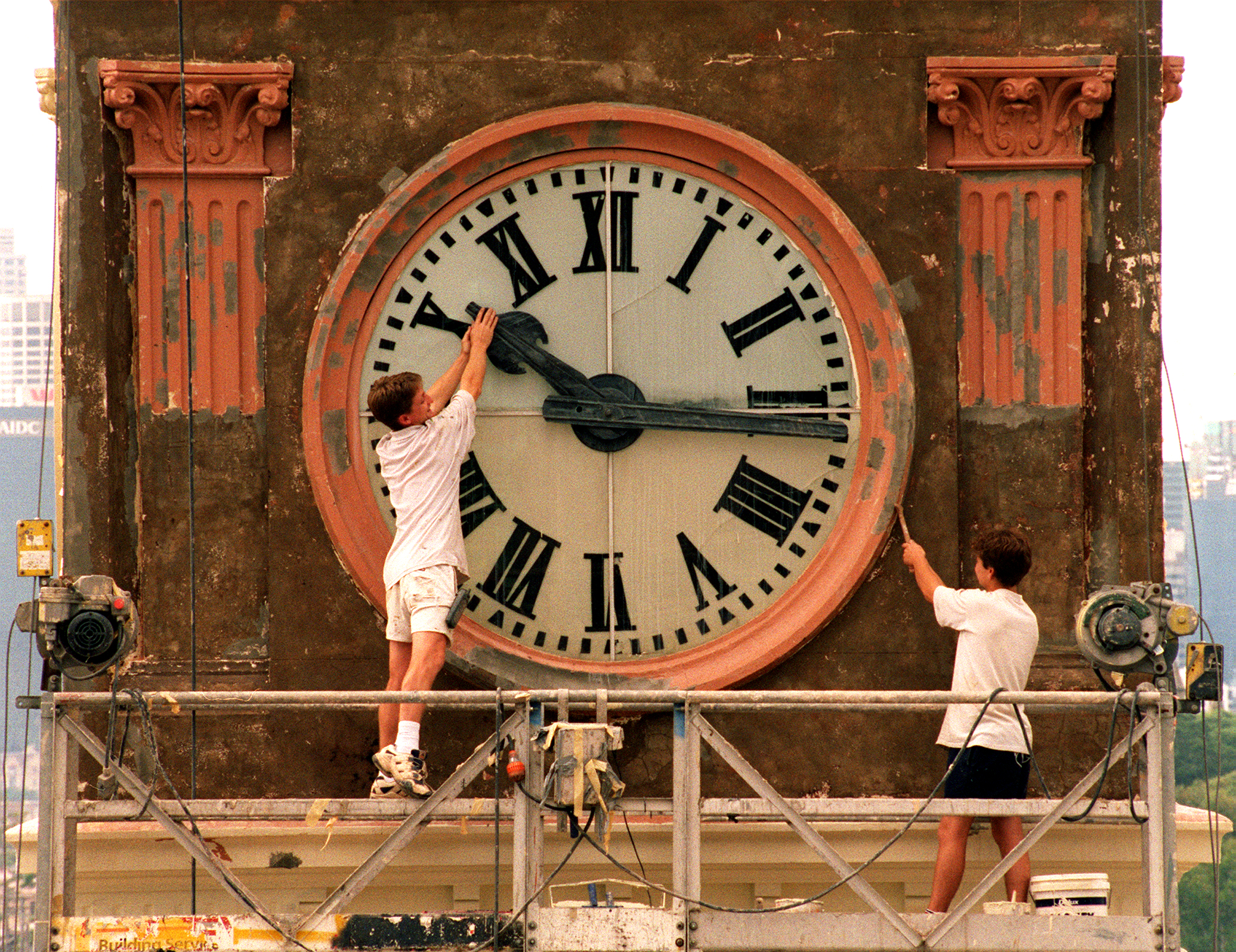 Daylight saving finishes this weekend with the clocks being put back one hour.Pic Shows; Painter, Wayne Fleming of Minchenbury working on the Balmian Post Office Tower clock, playfully trys to stop time while co-worker, David Hamilton works on.