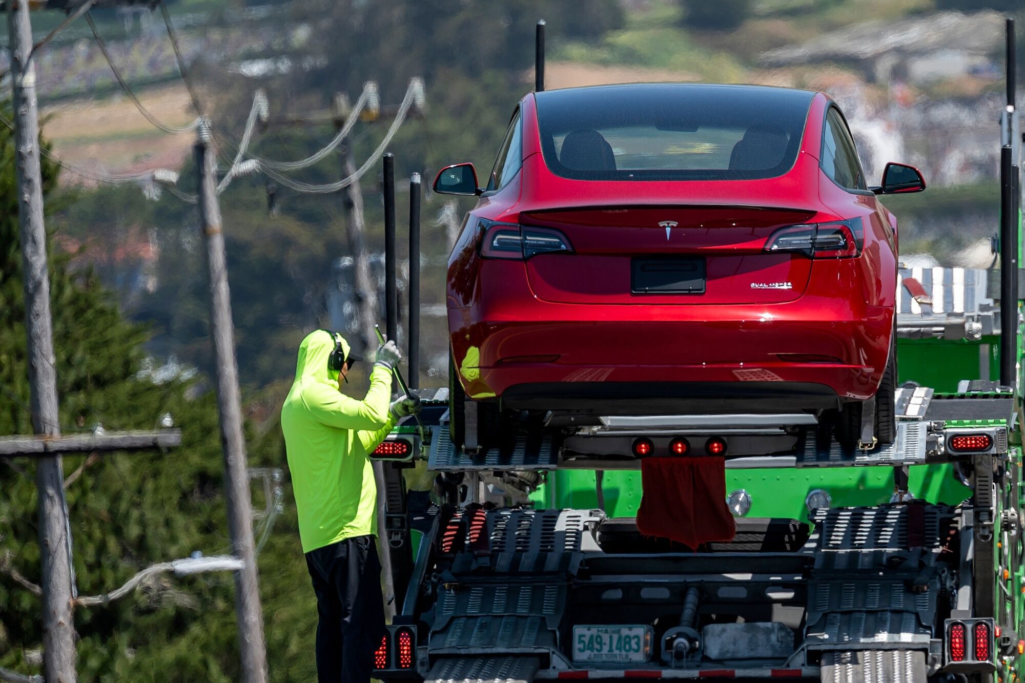 A Tesla Model 3 is loaded onto a vehicle transporter at the company's store in Colma, California, US, on Monday, April 21, 2025. Tesla Inc. shares fell on renewed questions over Elon Musk's role with the federal government and uncertainty over the company's plans to introduce a lower-cost electric vehicle. Photographer: David Paul Morris/Bloomberg
