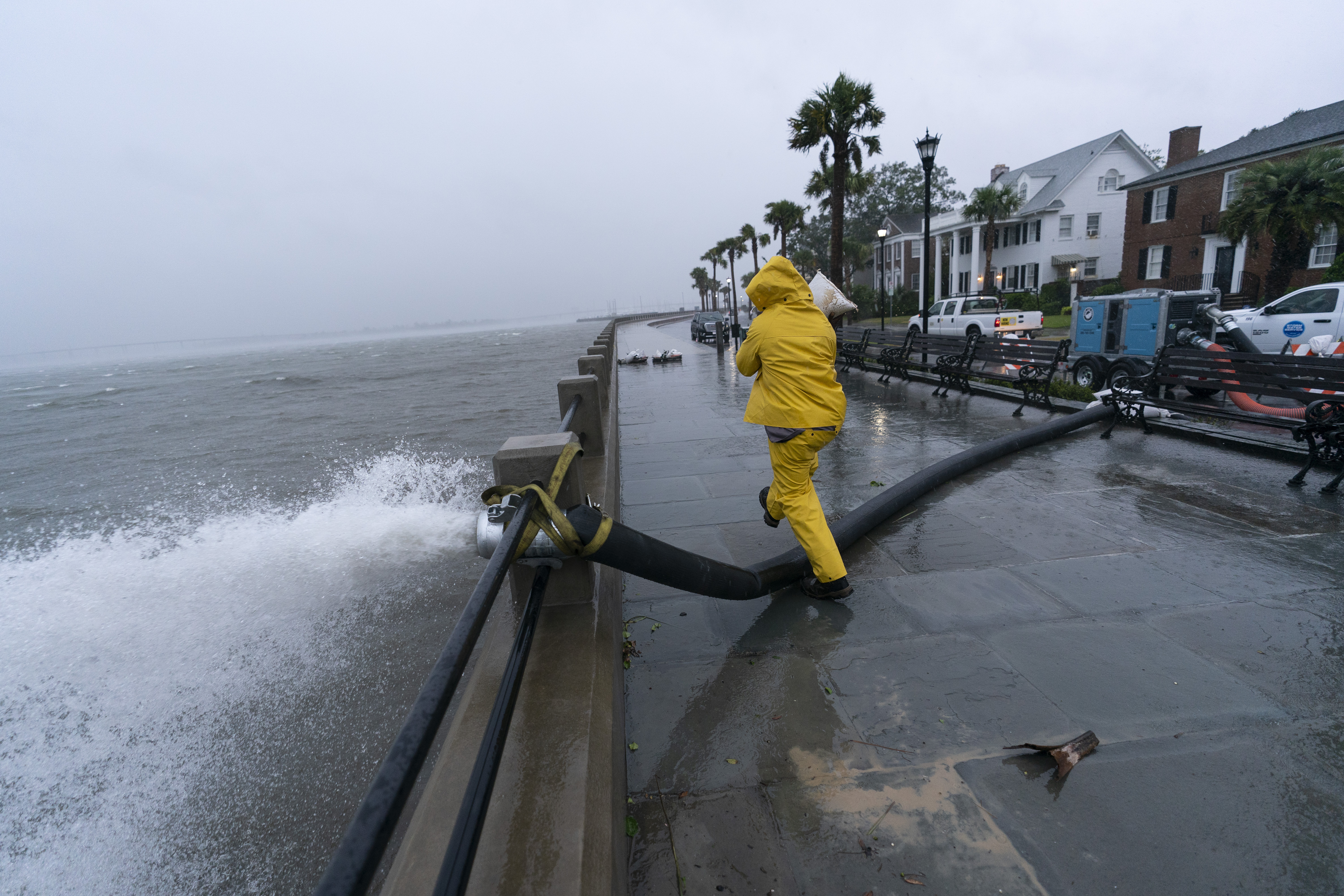 Un trabajador mueve una bolsa de arena después de que se colocó una bomba para extraer el agua de la batería mientras se sienten los efectos del huracán Ian, el viernes 30 de septiembre de 2022, en Charleston, Carolina del Sur.