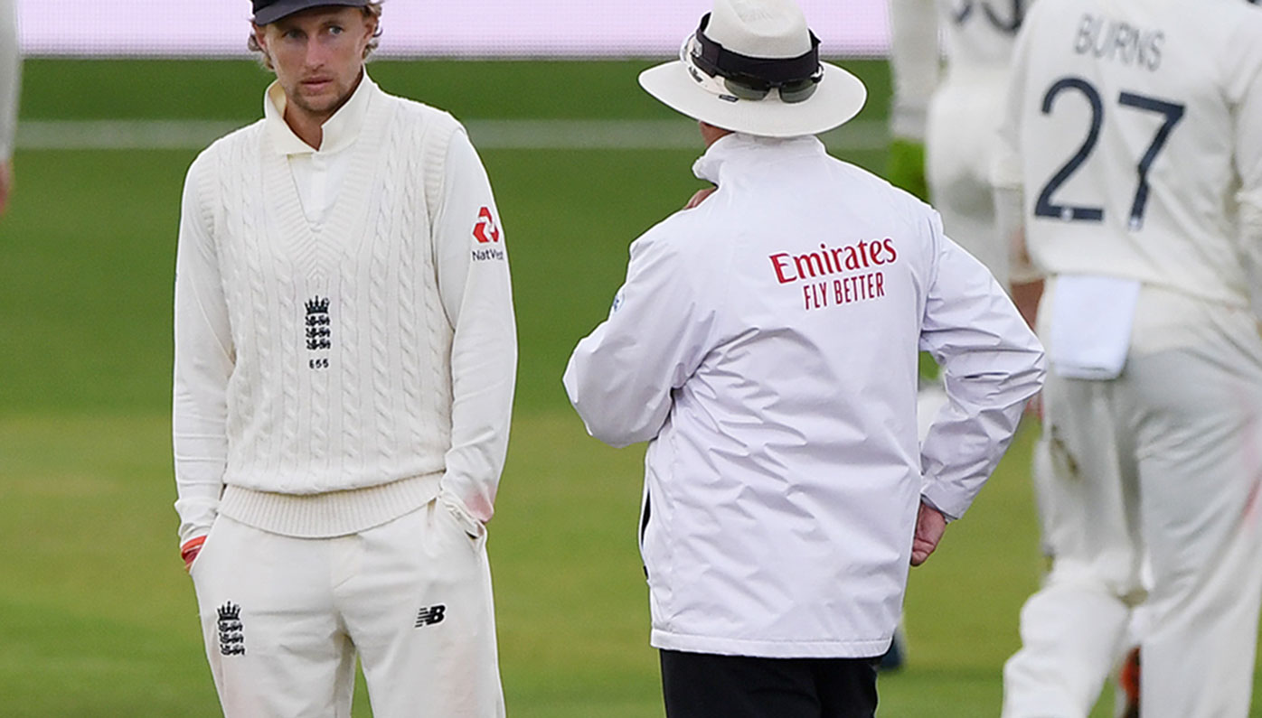 Joe Root speaks to umpire Richard Illingworth as bad light finally stops play on day three of the third Test.