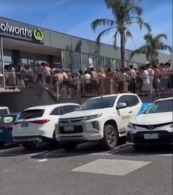 Vision shows hundreds of young beachgoers storming the Woolworths store.